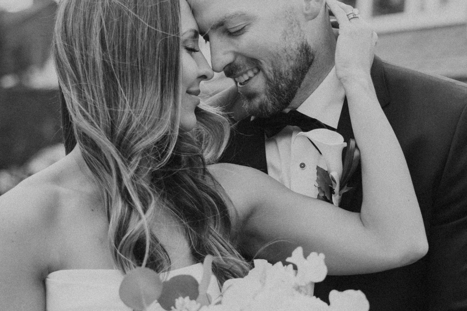 A romantic black and white photo series showing intimate moments between a couple on their wedding day.