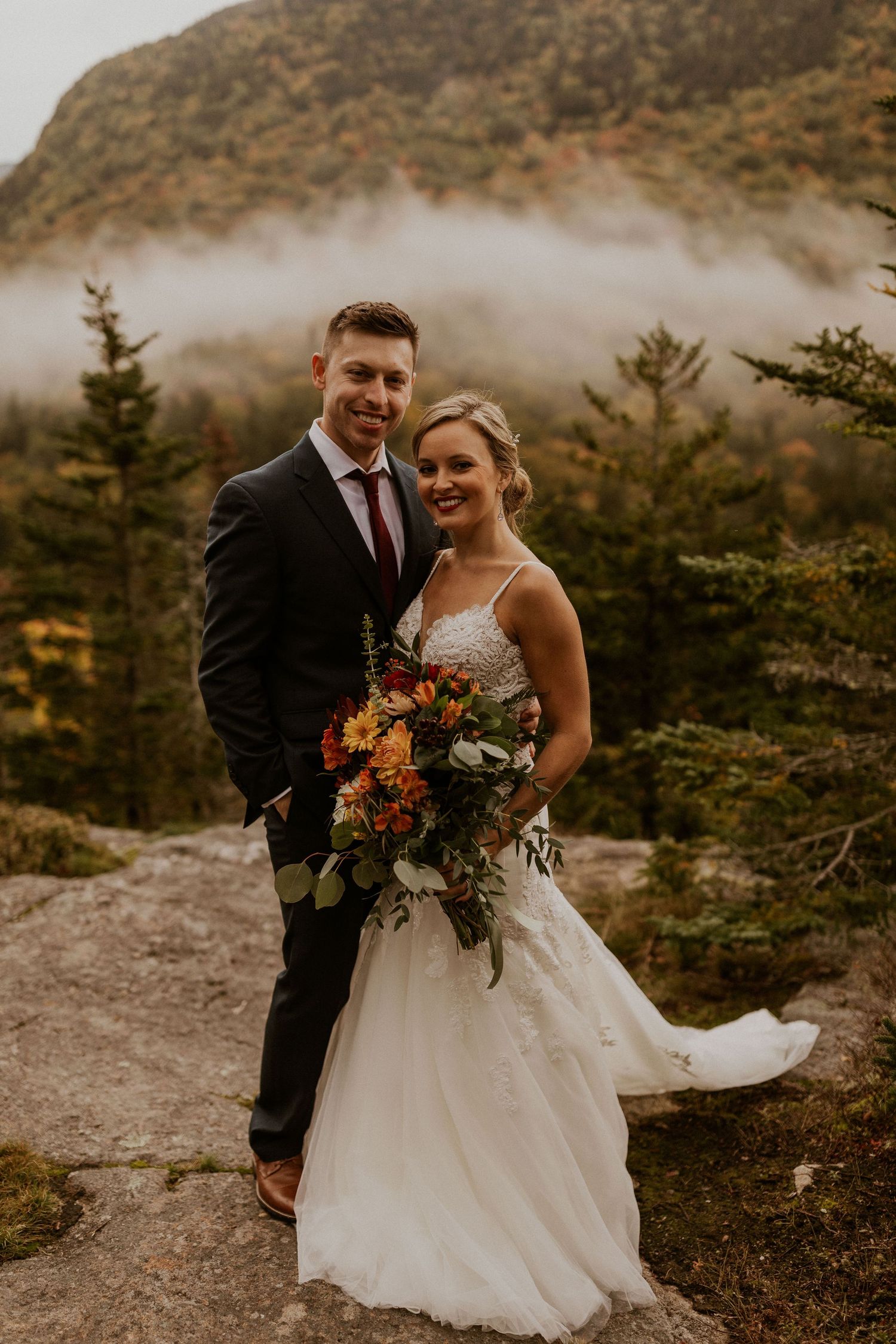 Newlyweds posing for mountaintop portraits in the White Mountain National Forest of New Hampshire.