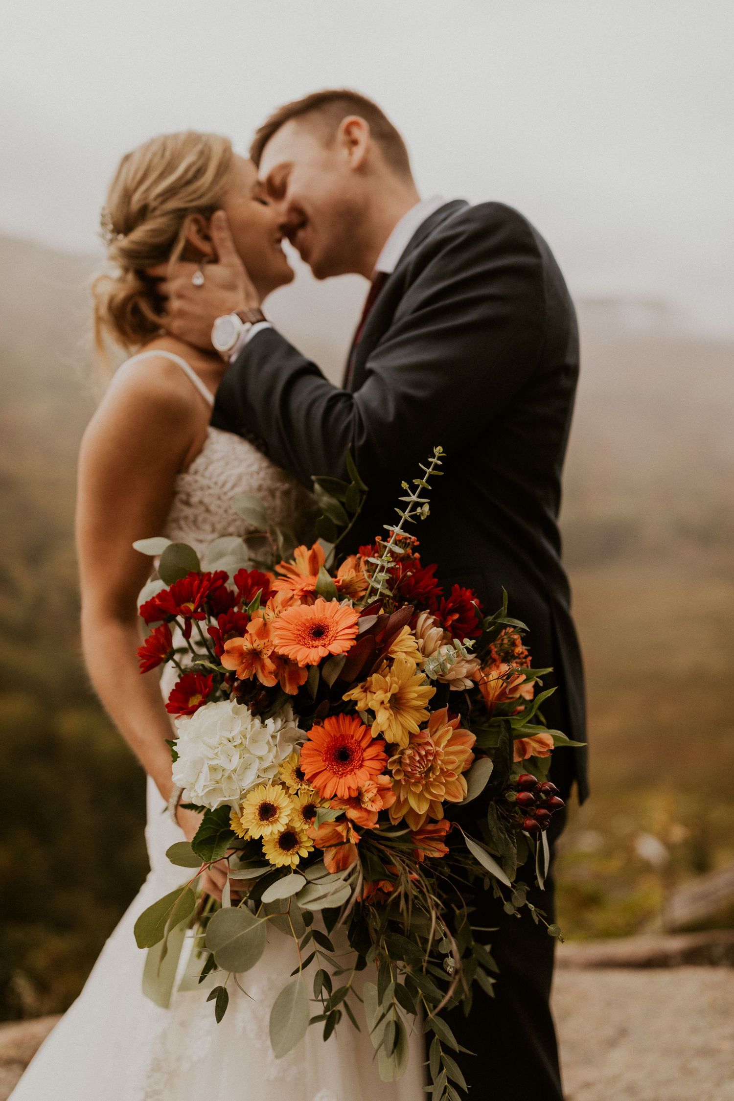 Newlyweds posing for mountaintop portraits in the White Mountain National Forest of New Hampshire.