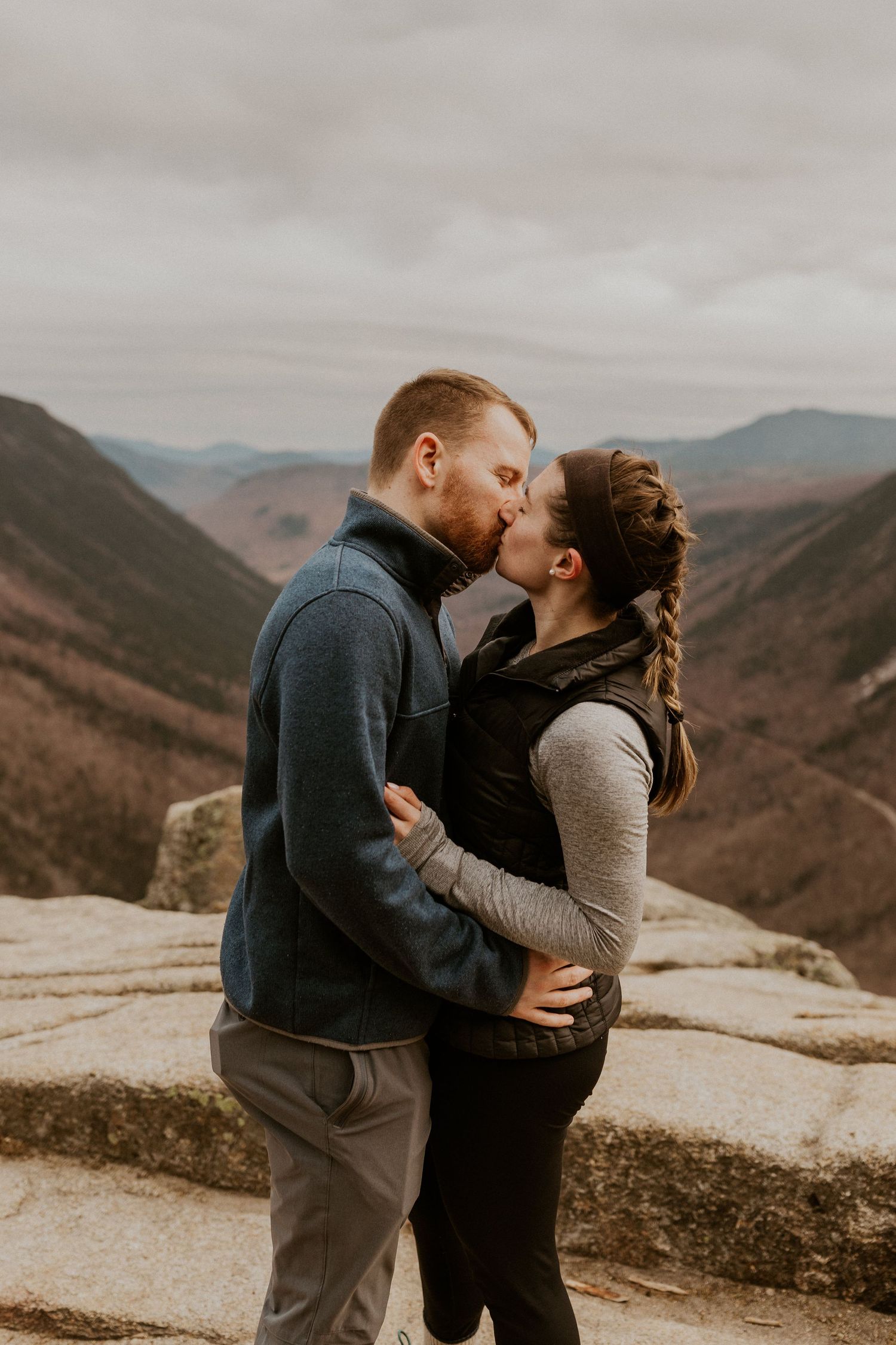 Newly engaged couple embracing each other on top of Mount Willard in the White Mountains of New Hampshire.
