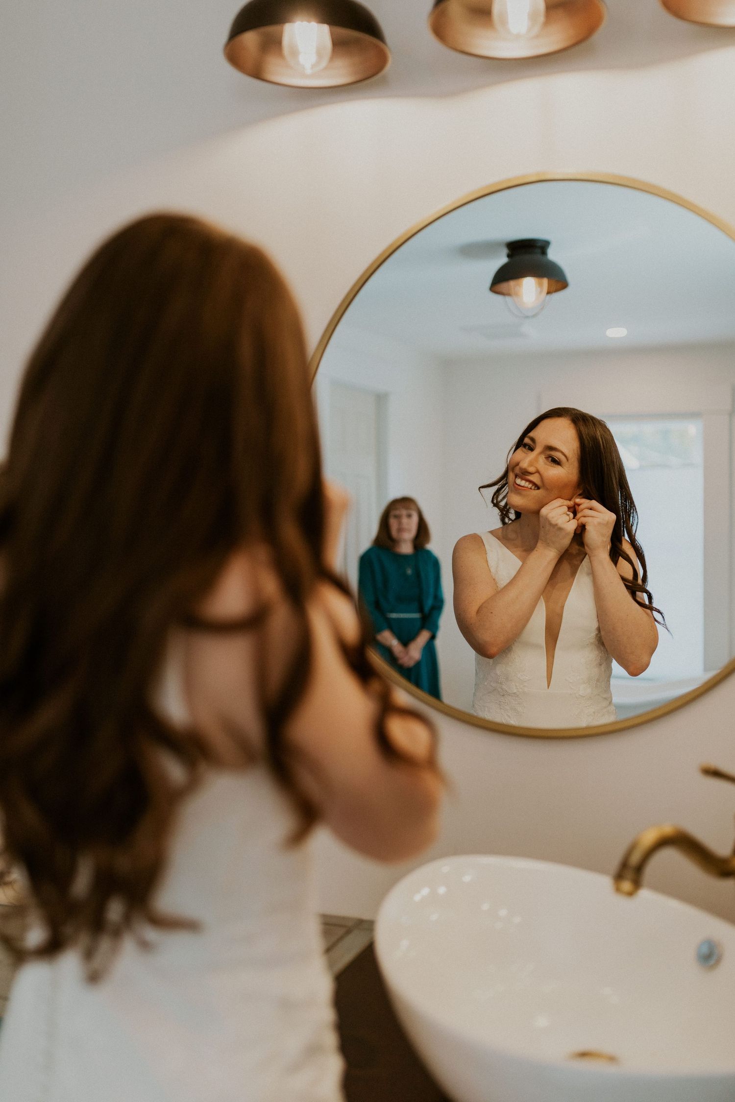 Briana, the bride, putting on her jewelry before her wedding ceremony on Loon Mountain.