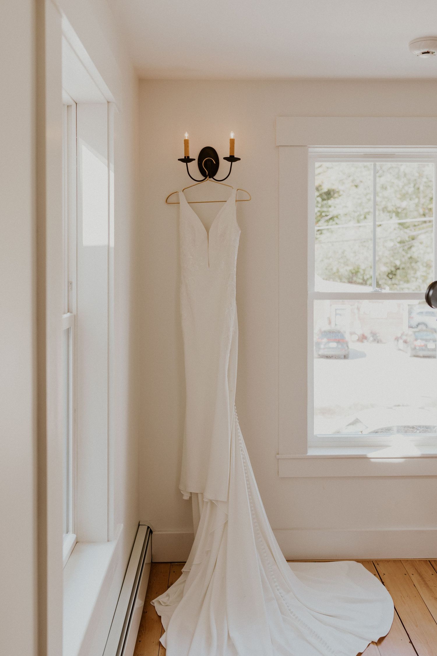 A photograph of Briana's wedding gown hanging in the hallway at the Woodstock Farmhouse in Woodstock New Hampshire.