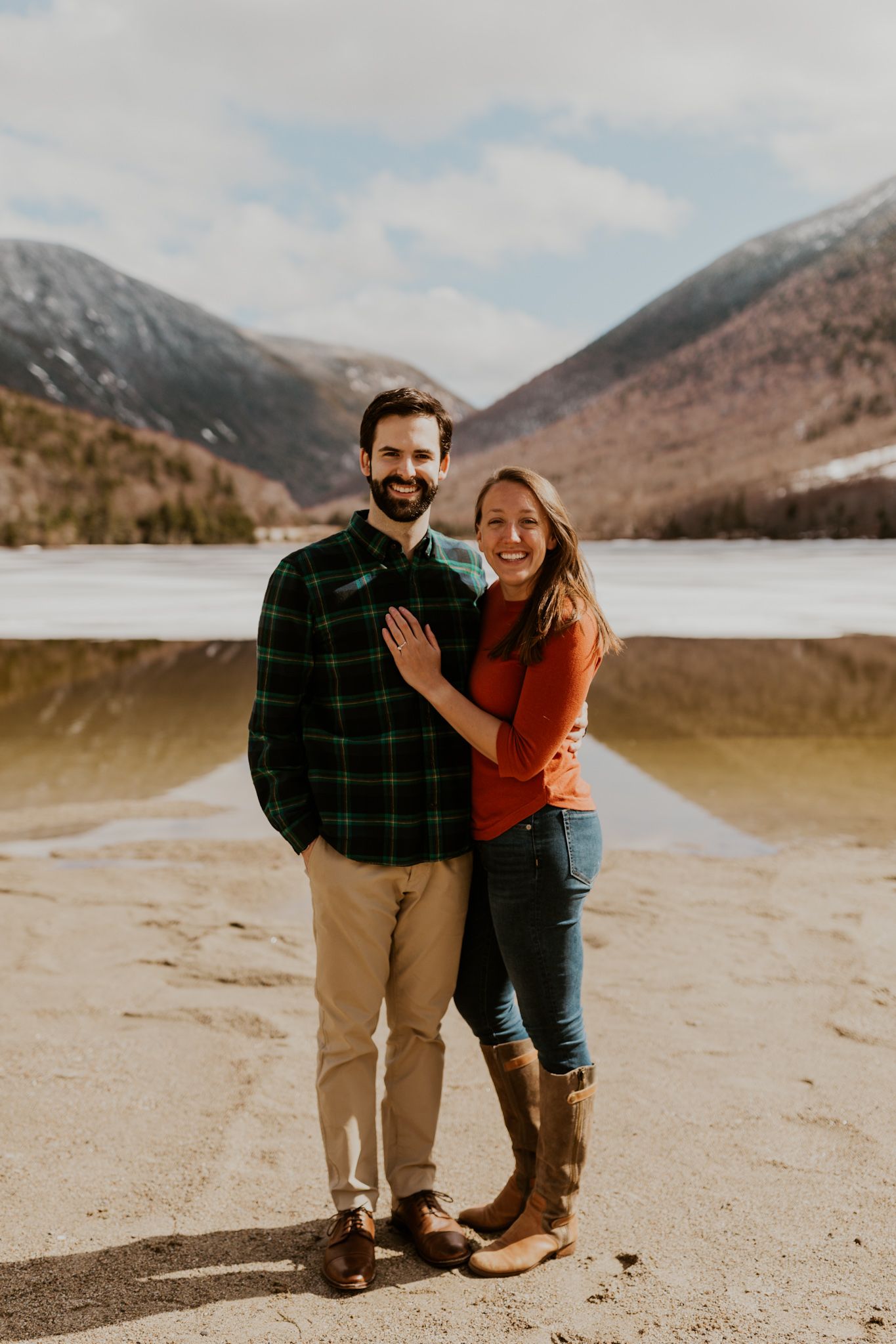 A happy couple standing in front of Echo Lake in Franconia Notch State Park