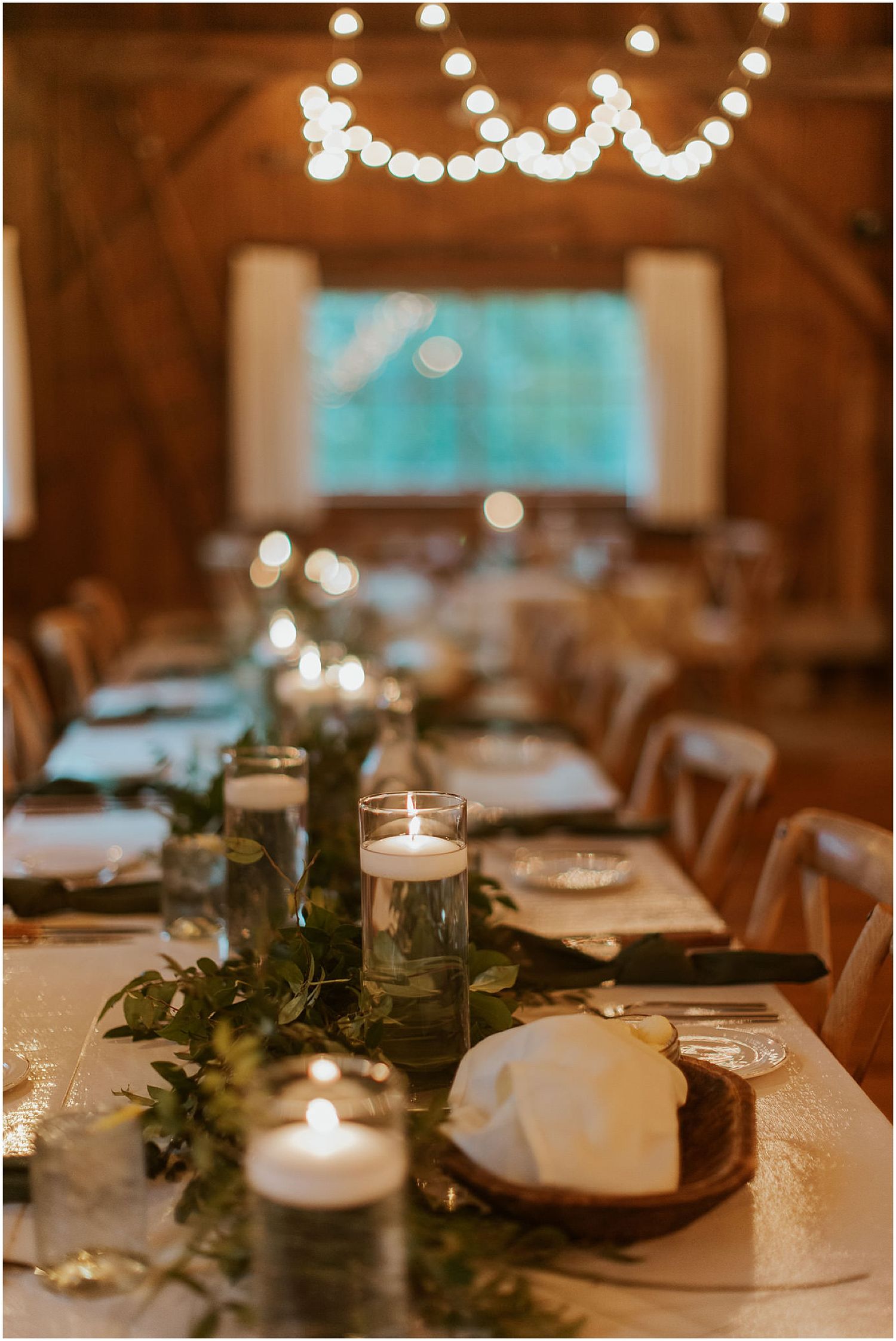 Wedding table decor with greenery and white candles