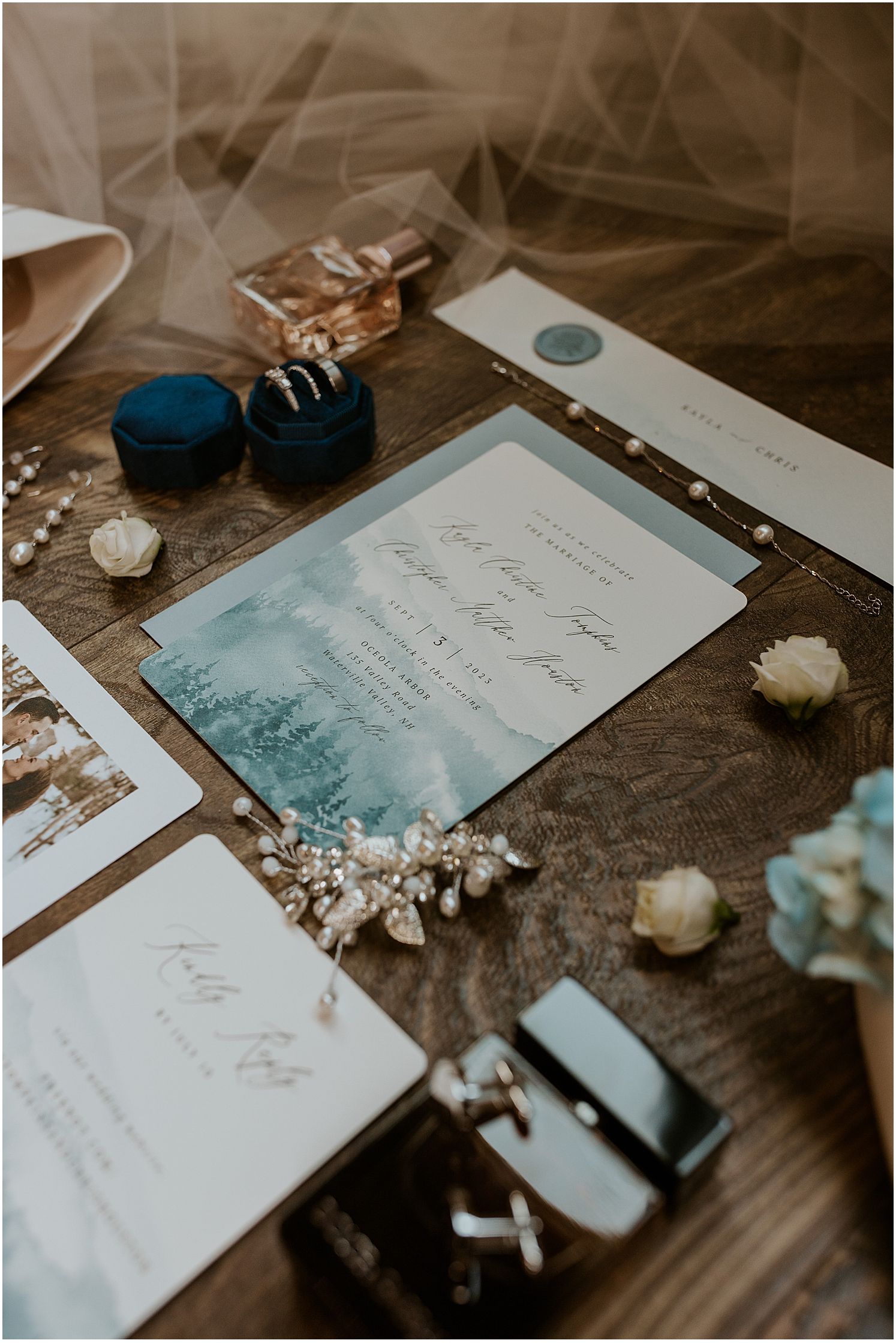 Wedding invitations and stationery in soft blue watercolor design with white floral accents.