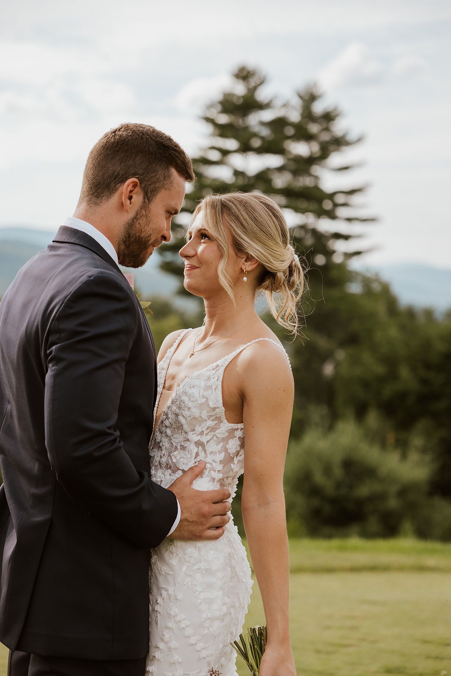Bride and groom taking romantic portraits outside their wedding at the Sunset Pavilion at the Owl's Nest Resort in New Hampshire