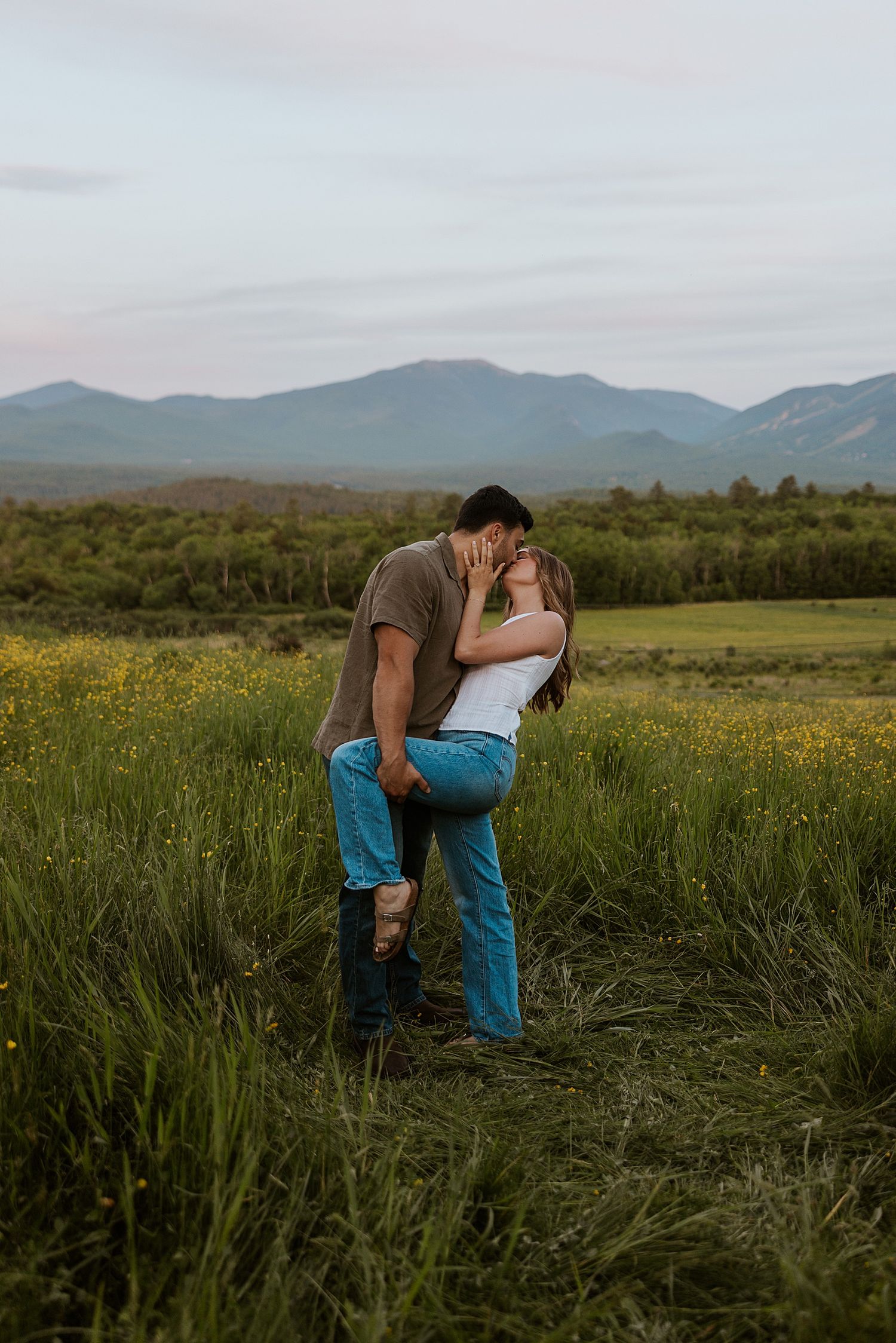 Couple sharing a dip kiss during their golden hour engagement photo session in New Hampshire