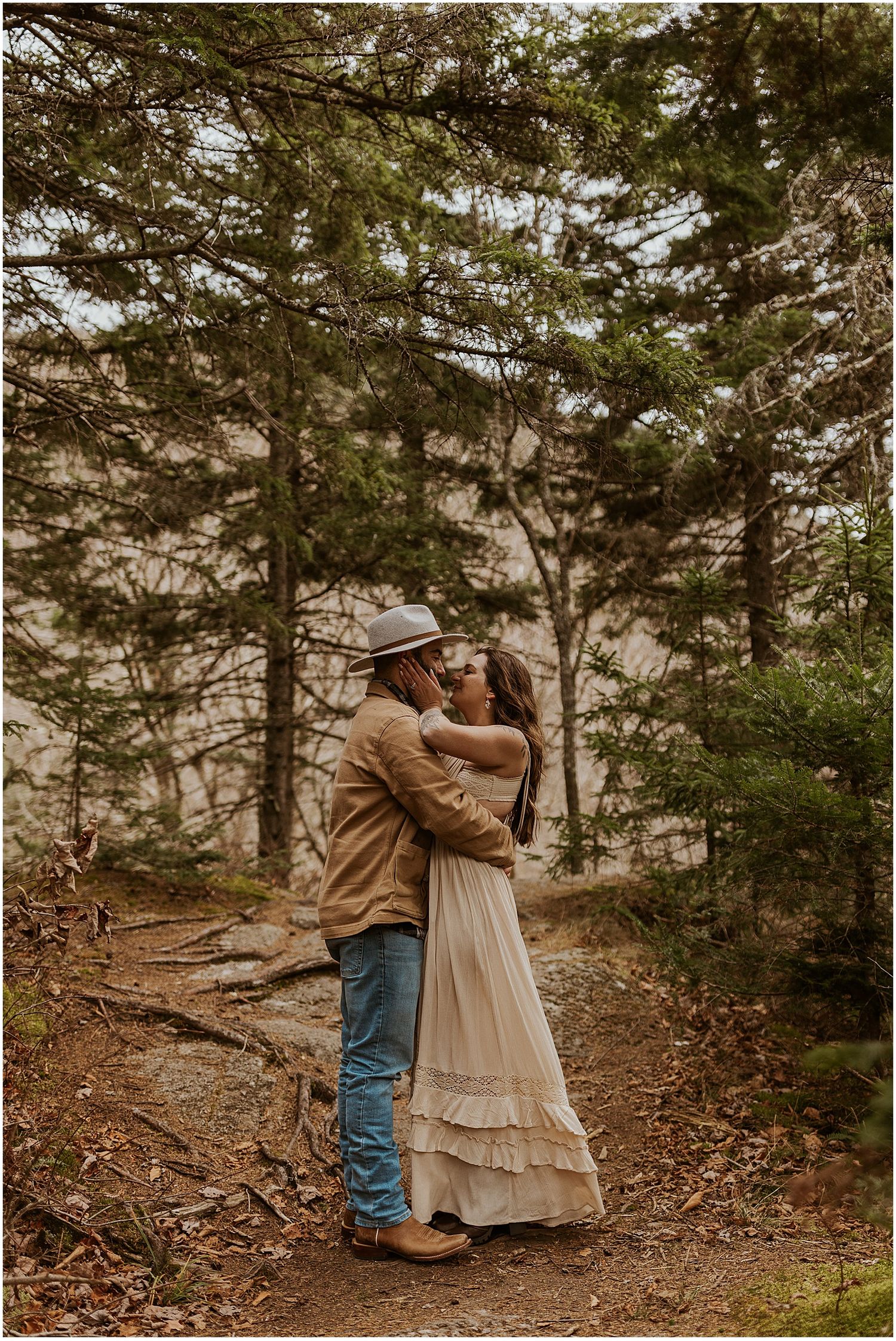 Couple taking engagement photos in the woods in NH