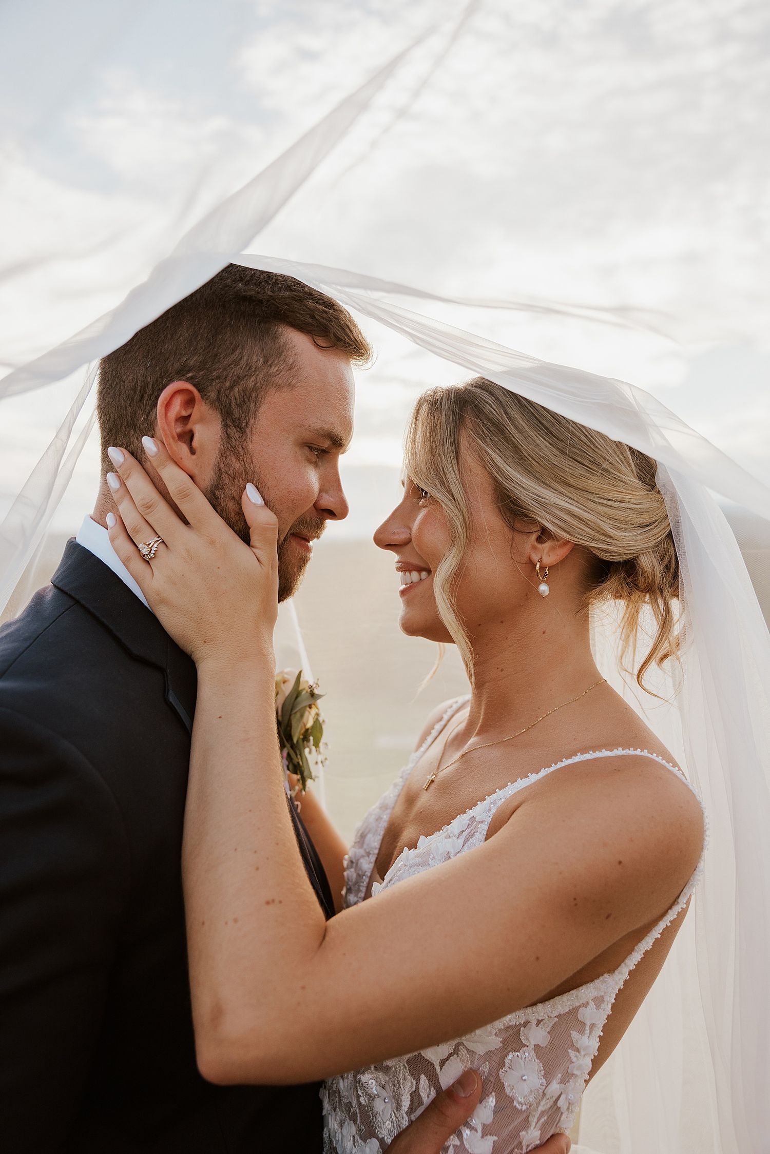 Bride and groom taking portraits under her veil at their wedding at the Sunset Pavilion at the Owl's Nest Resort in NH