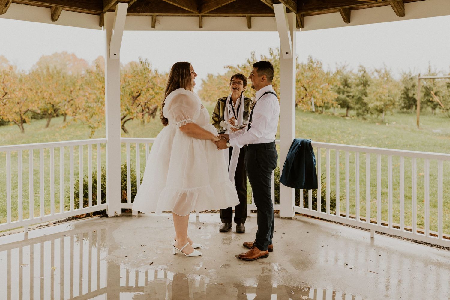 Terise and Jose holding hands during their ceremony at Carter Hill Orchard in Concord New Hampshire.
