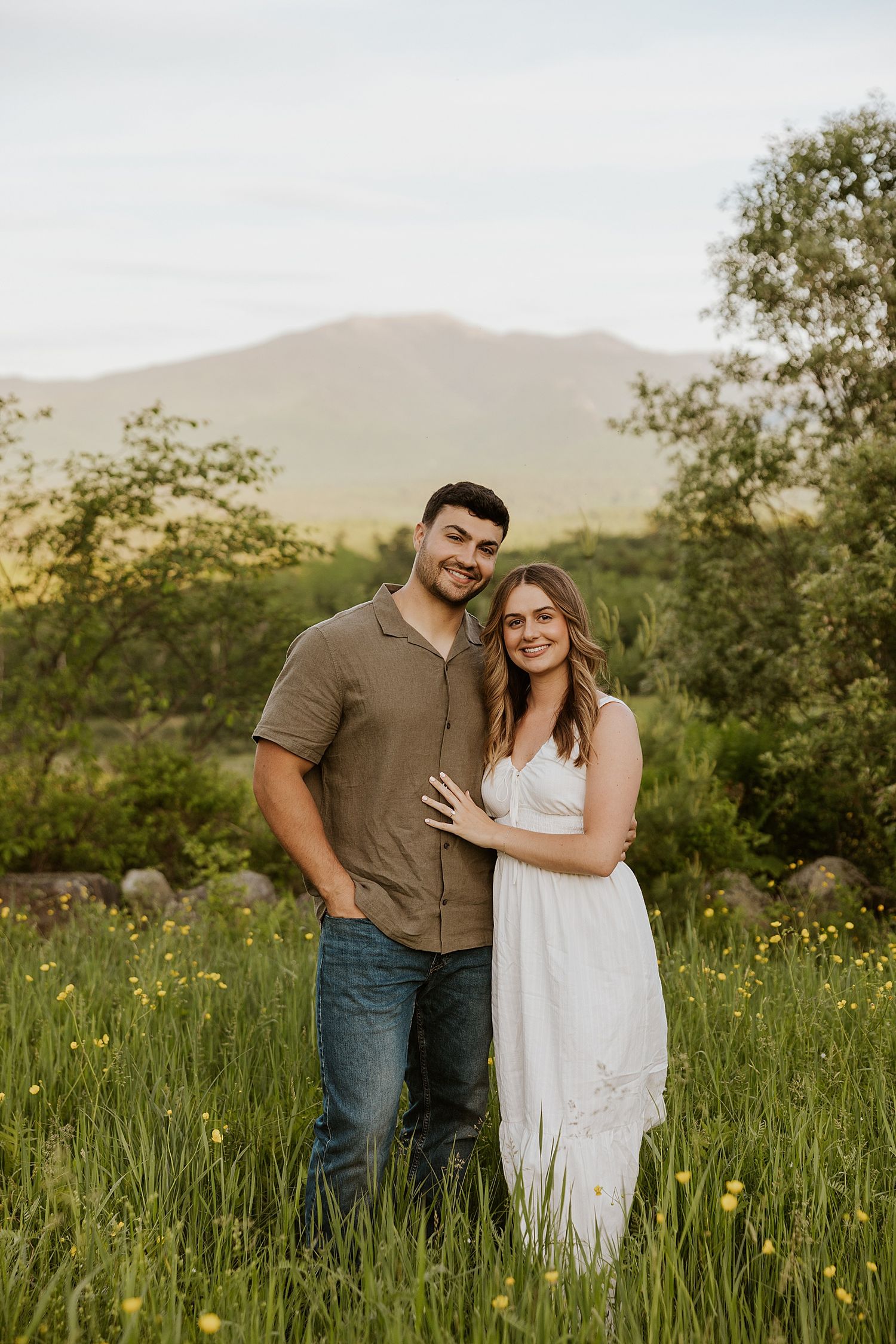 New Hampshire couple posing in a field while taking engagement pictures