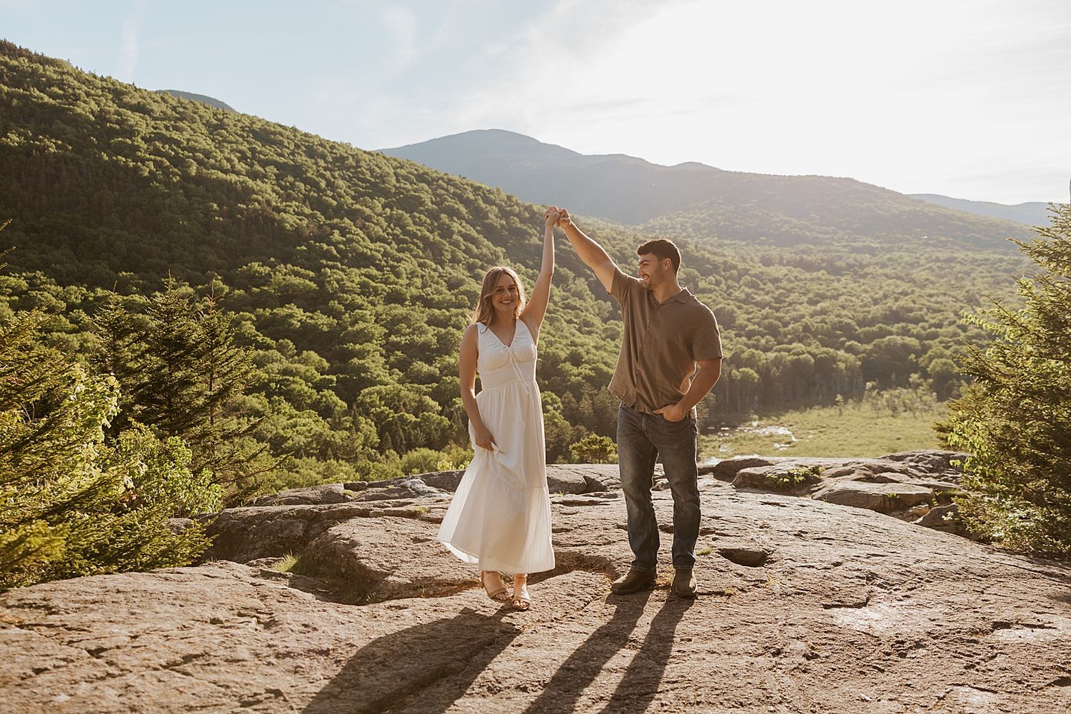 Couple taking engagement photos at golden hour in the NH White Mountains