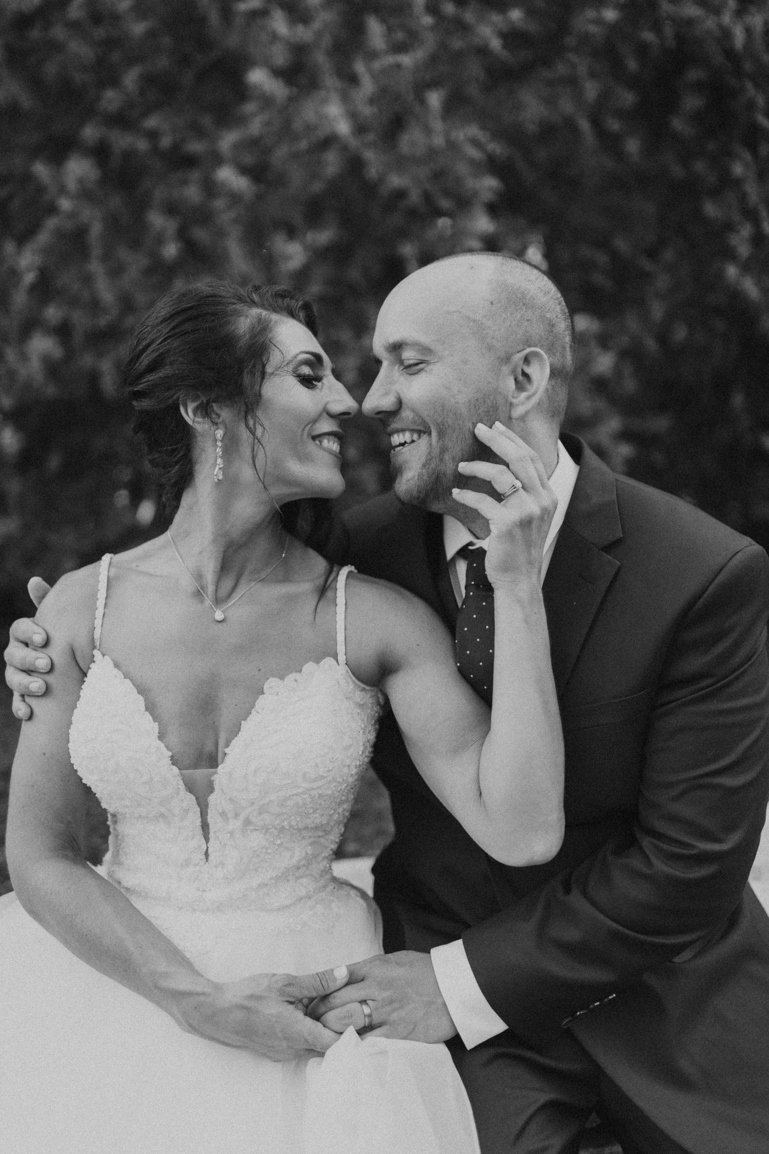 Black and white portrait of tender wedding moment between couple.