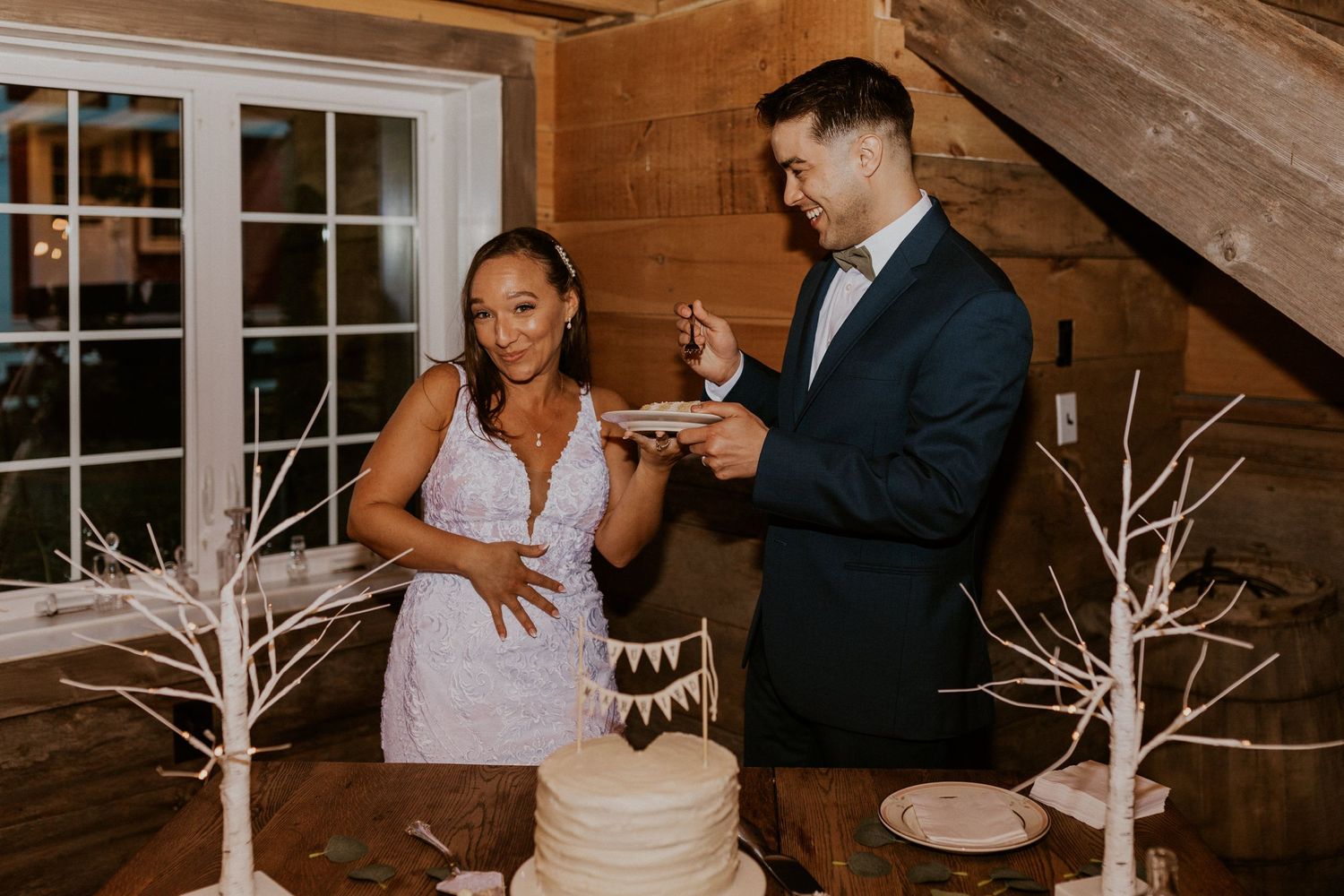 Wedding couple feeding each other cake during their reception celebration.