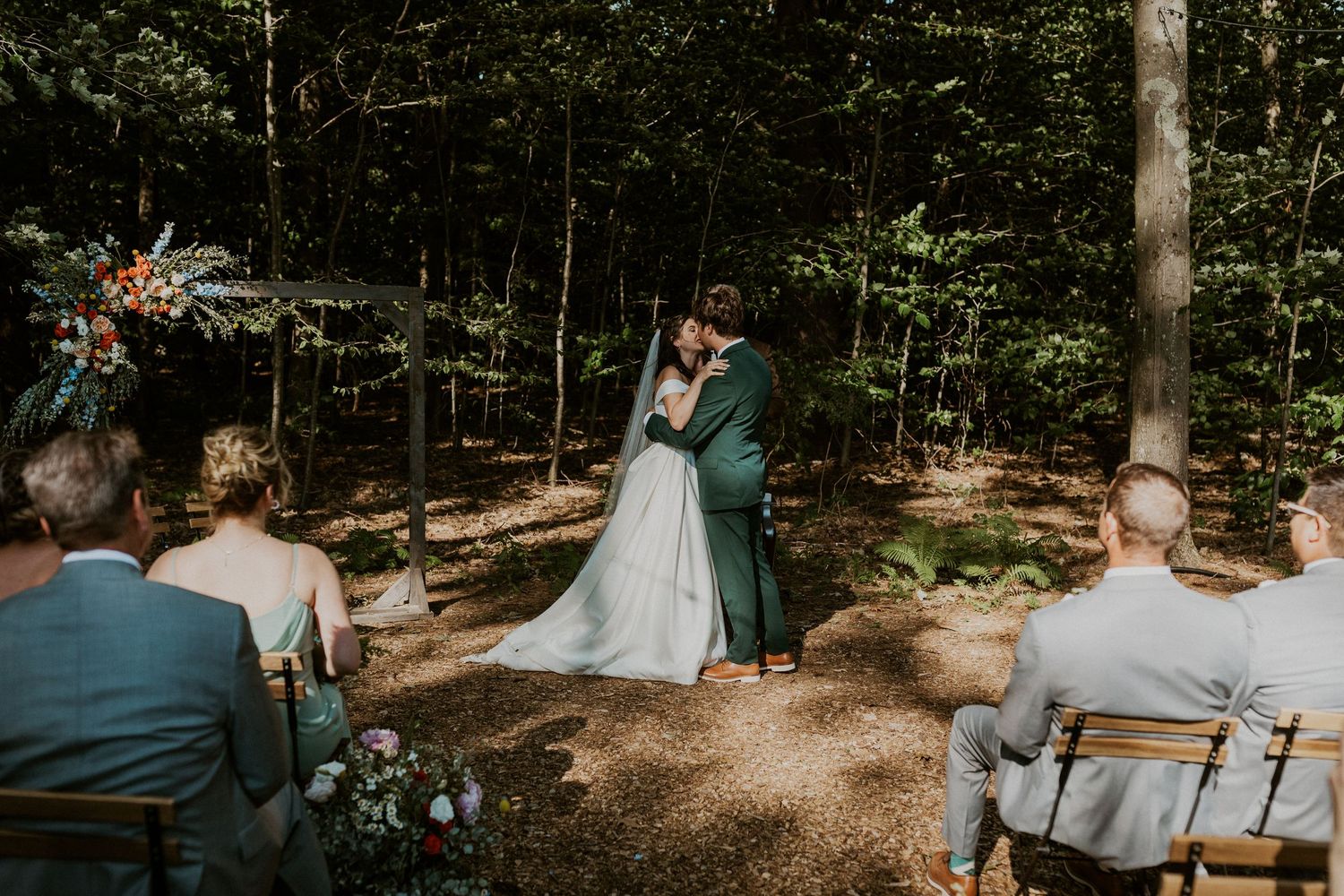 Forest wedding ceremony setup with natural lighting filtering through the trees.