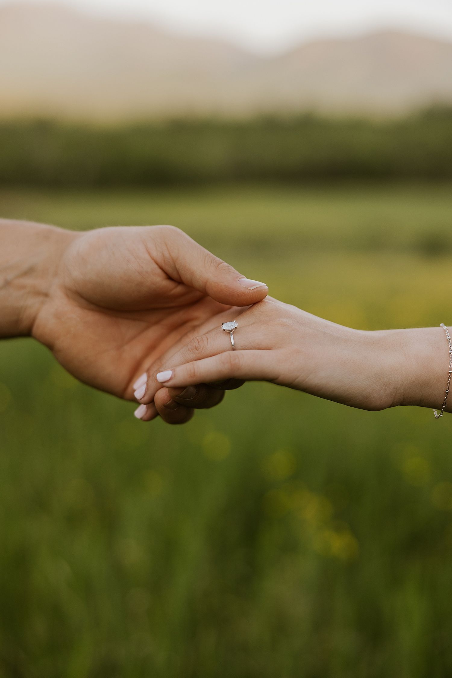 Couple holding hands during their New Hampshire engagement photo session at golden hour