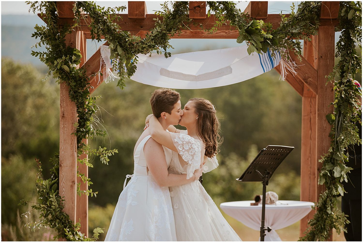 Brides sharing their first kiss at their New Hampshire wedding ceremony