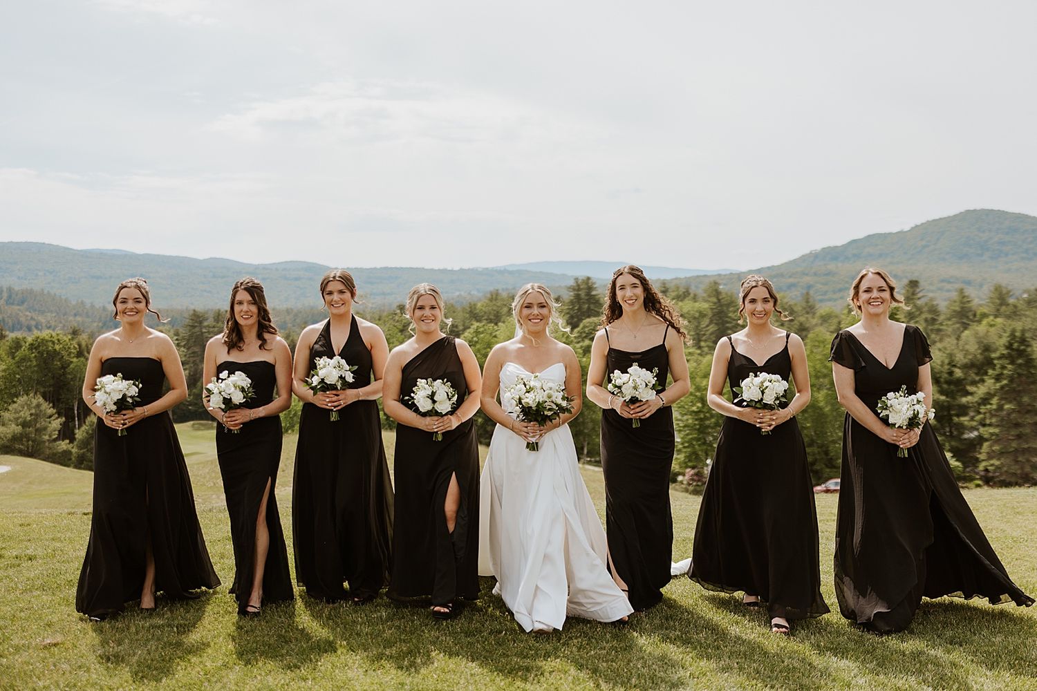 Bride taking portraits with her bridesmaids in the mountains at a New Hampshire wedding