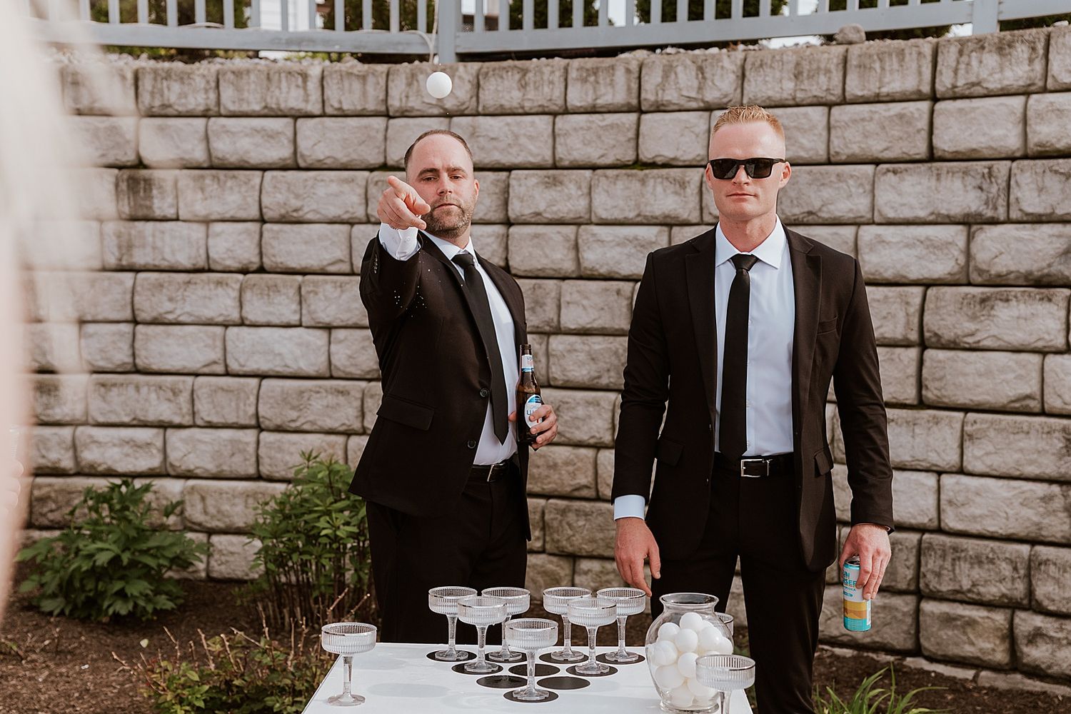 Groom and groomsmen playing beer pong during cocktail hour at an Owl's Nest wedding in NH