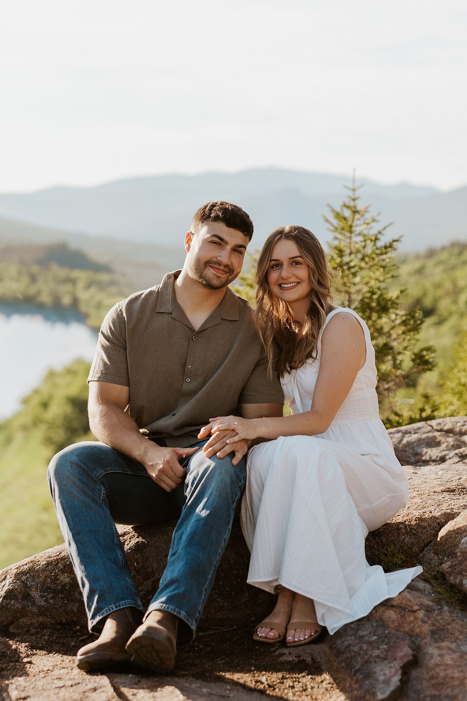New Hampshire couple sitting on a rocky ledge in the White Mountains