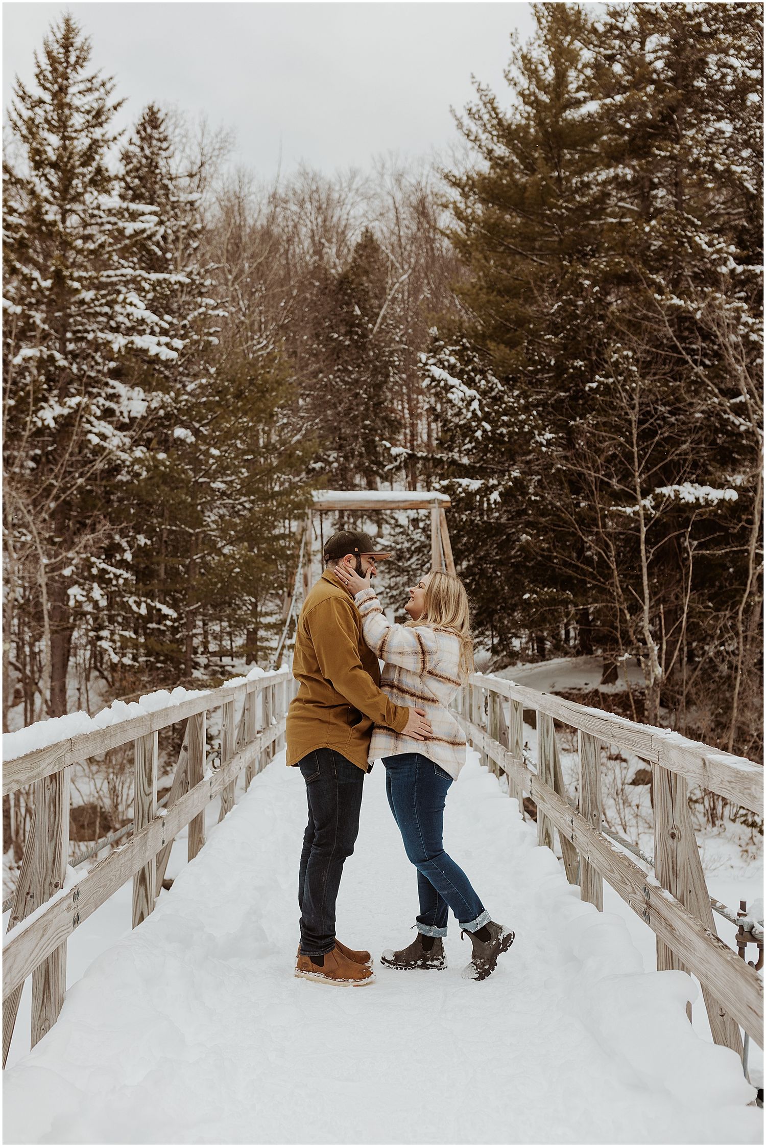 New Hampshire couple taking engagement pictures in their best winter engagement photo outfits
