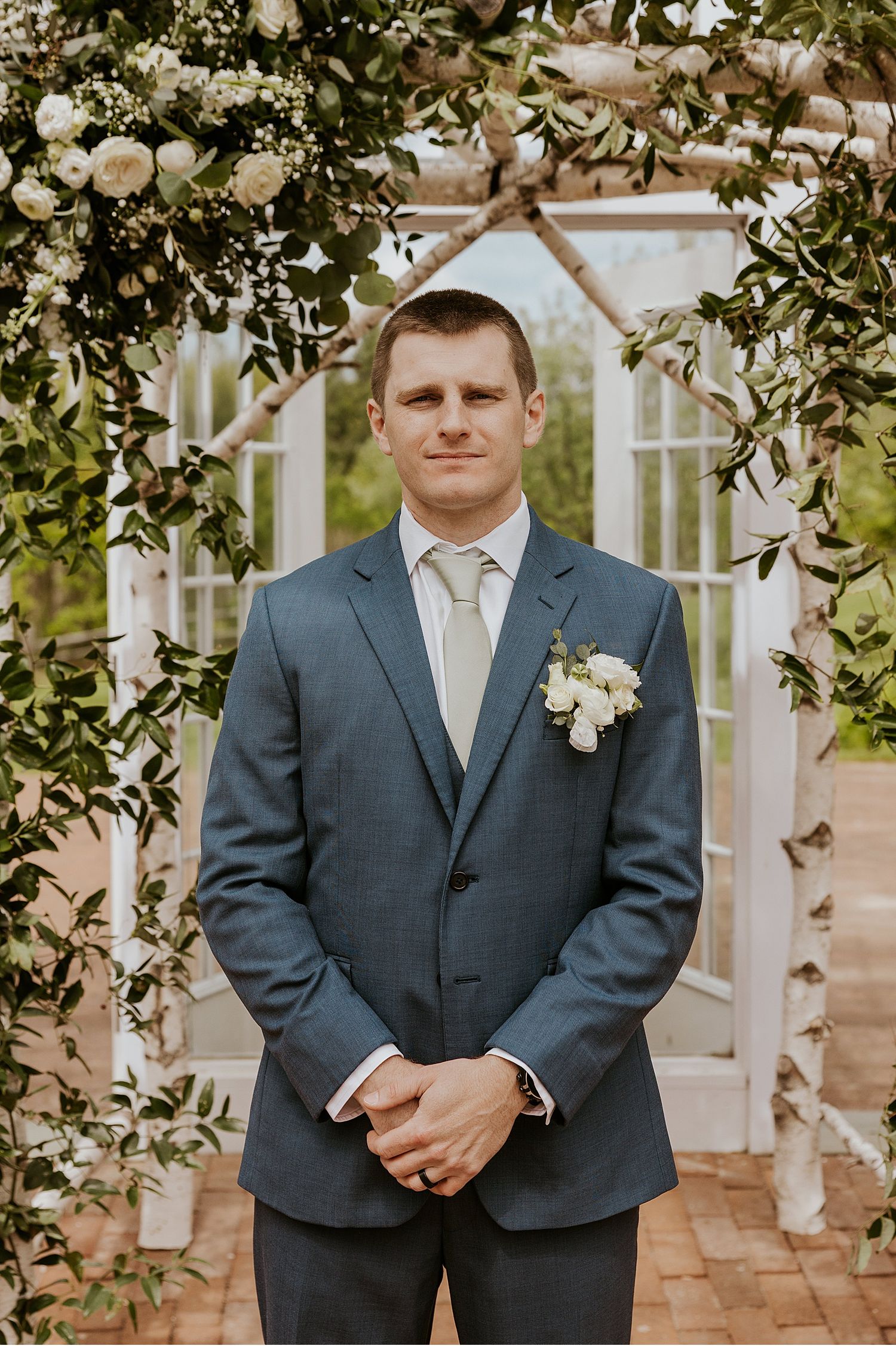 Groomsmen in navy blue suits standing in formal poses with white boutonnieres.