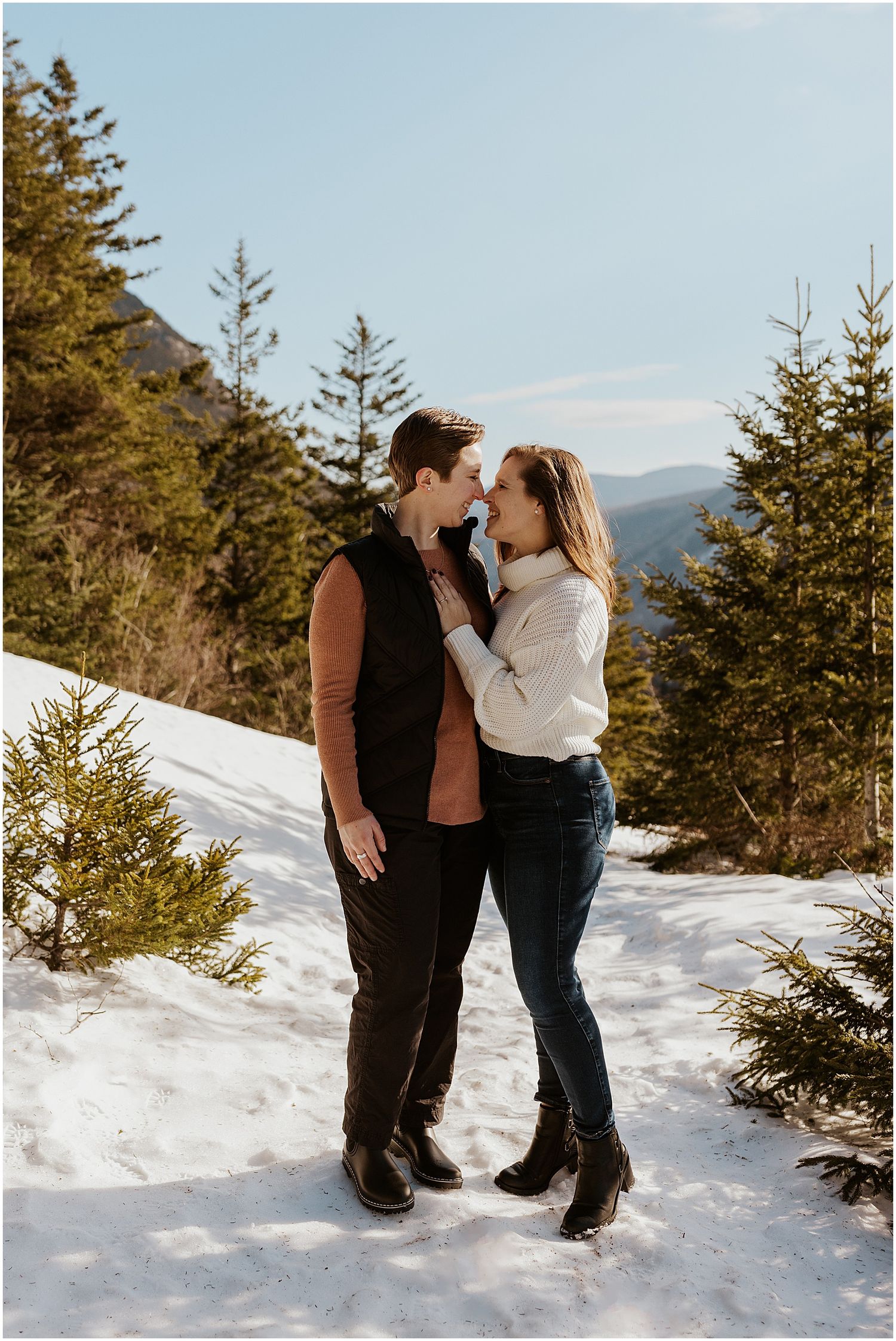 A romantic winter photoshoot among snow-covered evergreen trees in the mountains.