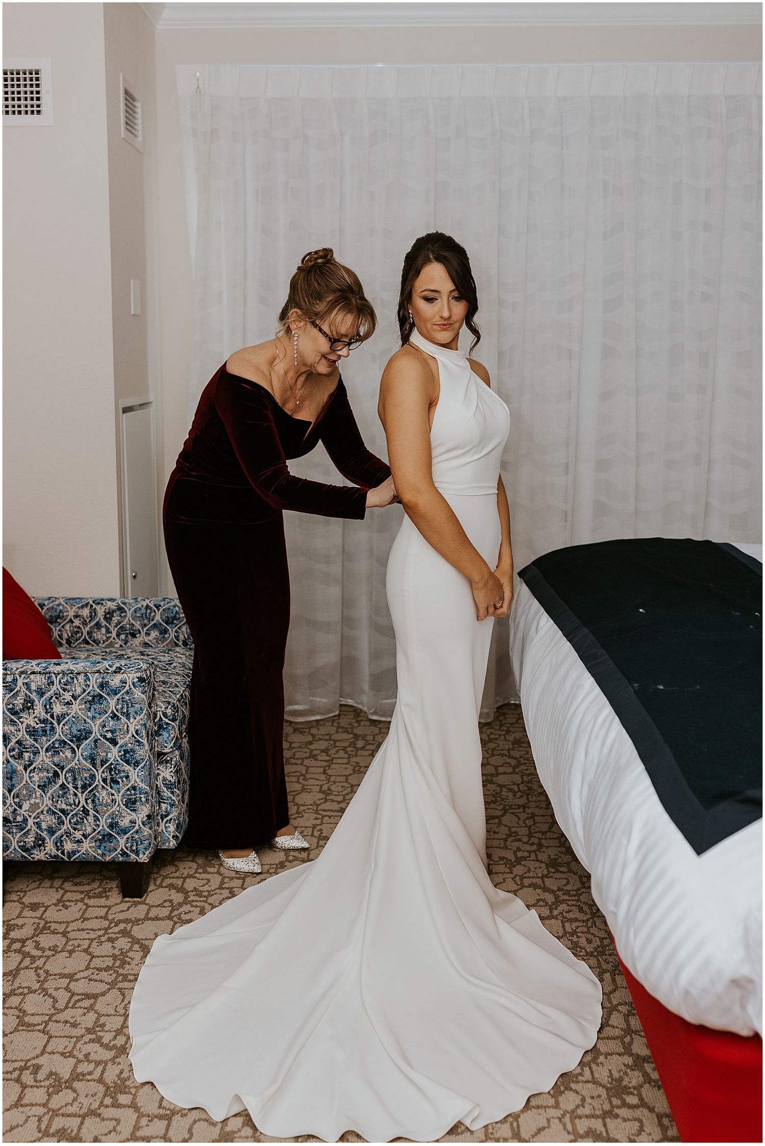 Mother of the bride buttoning bride's dress at a Loon Mountain wedding at River Walk Resort