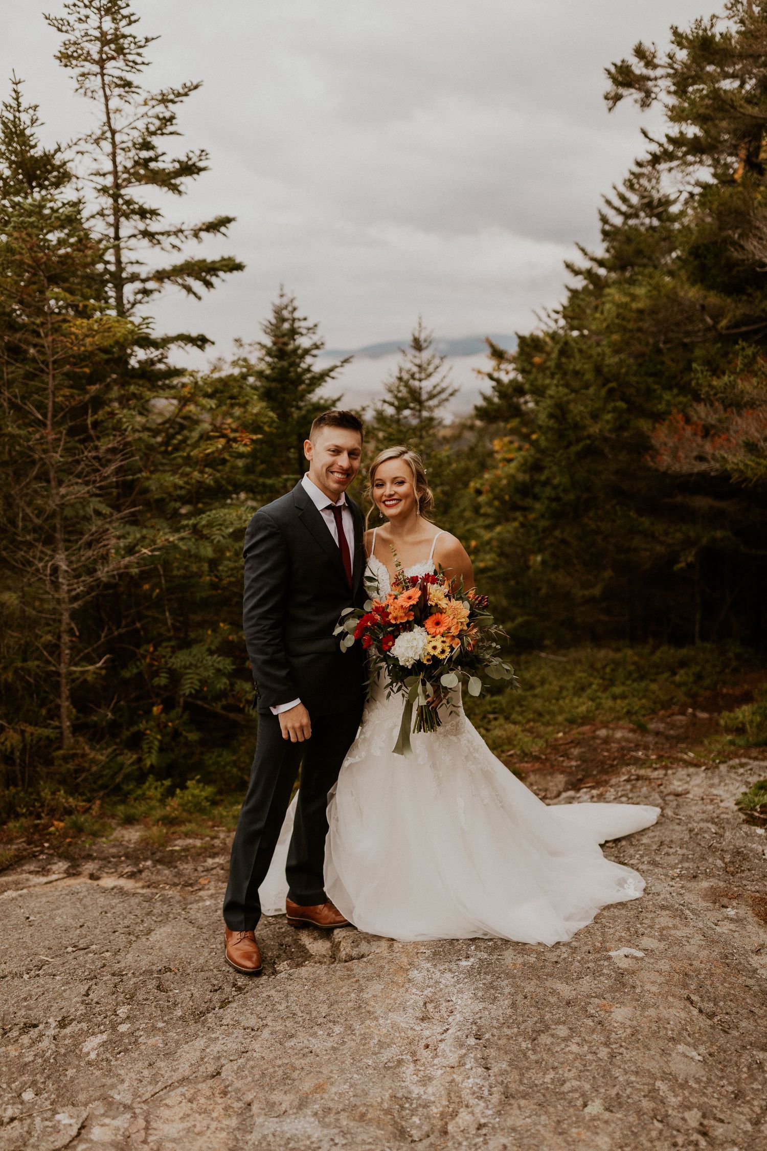 Newlyweds posing for mountaintop portraits in the White Mountain National Forest of New Hampshire.