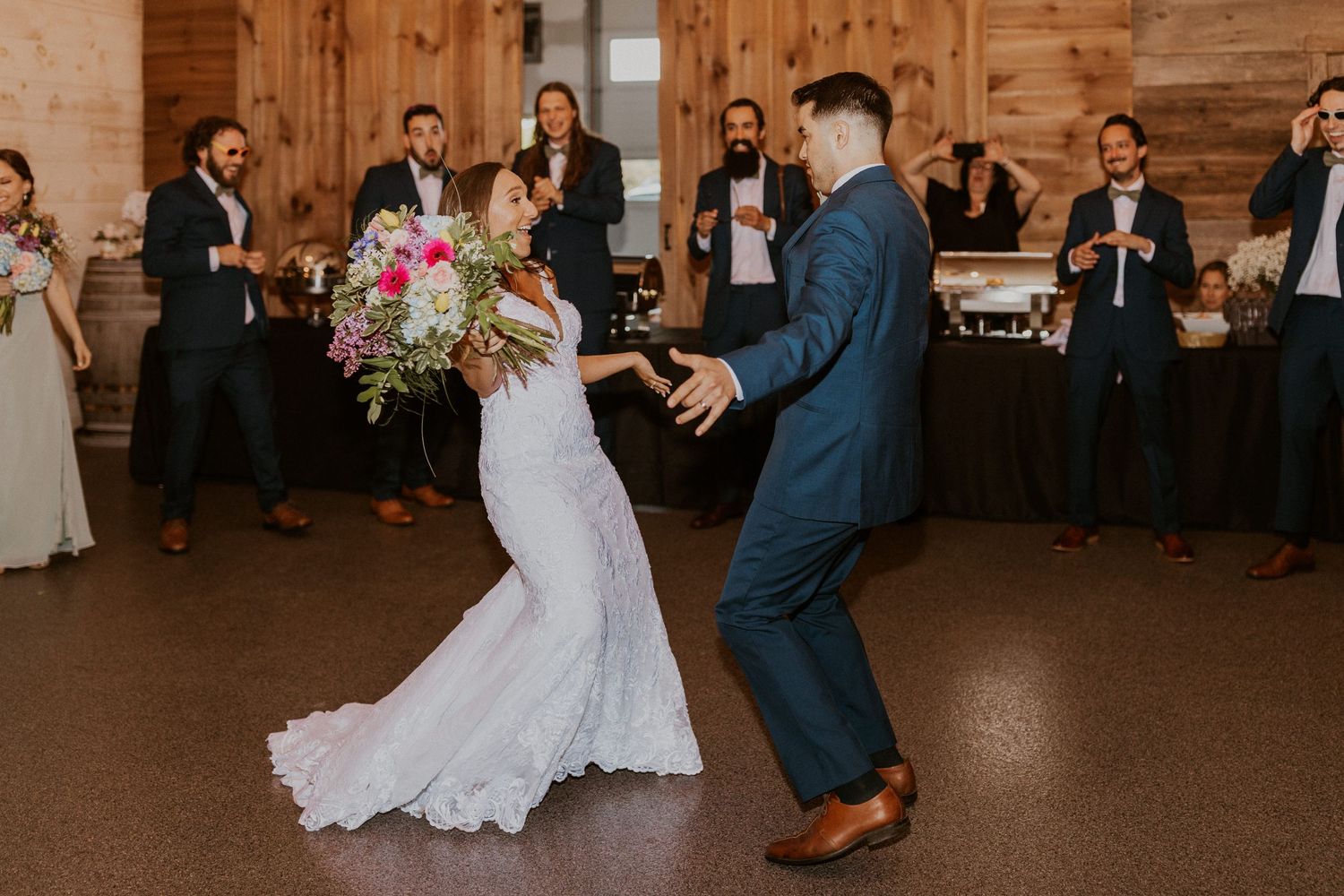 Couple shares an intimate moment during their first dance in a rustic barn reception venue.