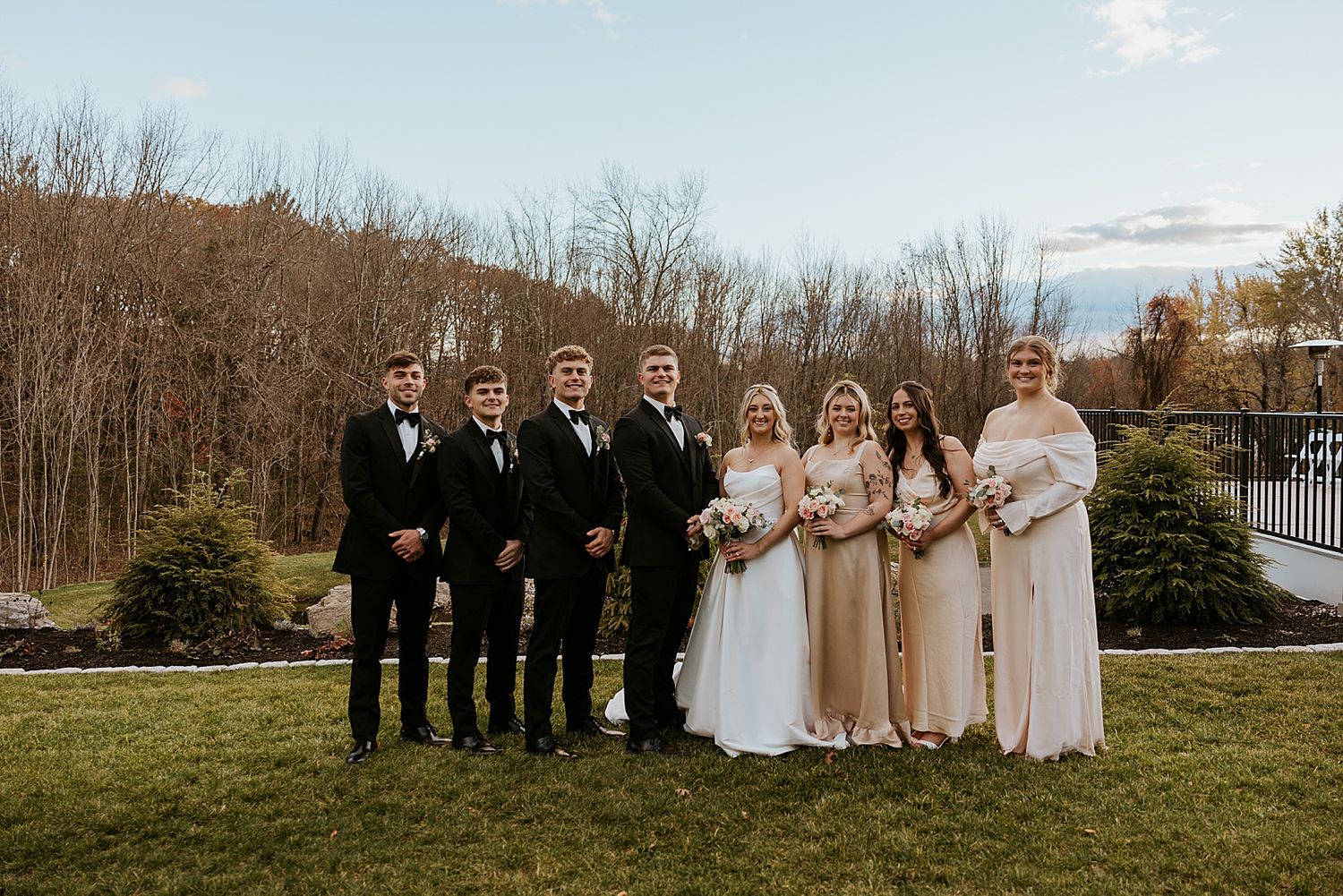 Bride and groom posing for portrait photos with their wedding party at Hyla Brook Estate in NH