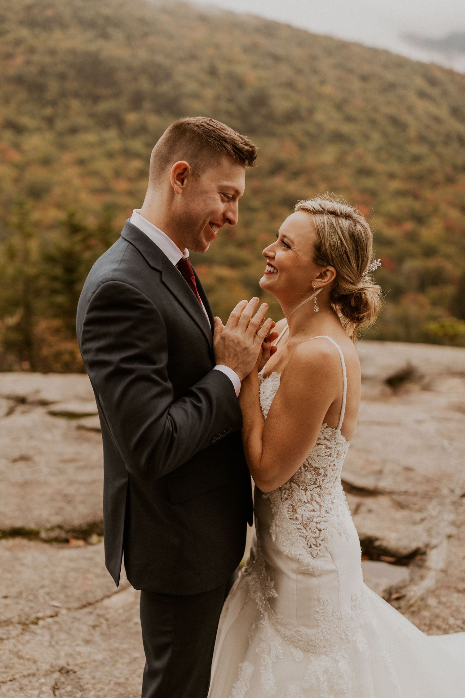 Newlyweds posing for mountaintop portraits in the White Mountain National Forest of New Hampshire.