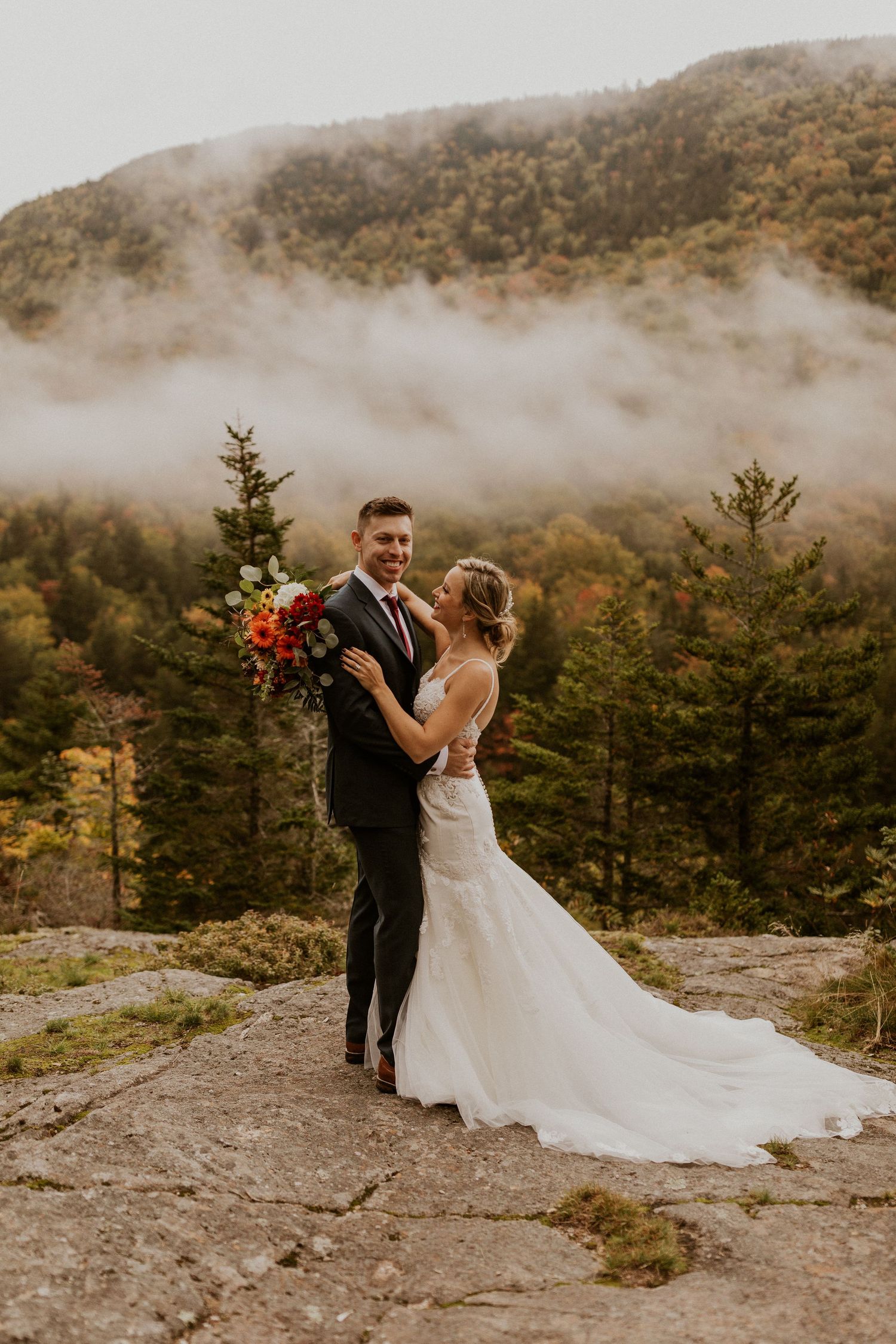 Newlyweds posing for mountaintop portraits in the White Mountain National Forest of New Hampshire.
