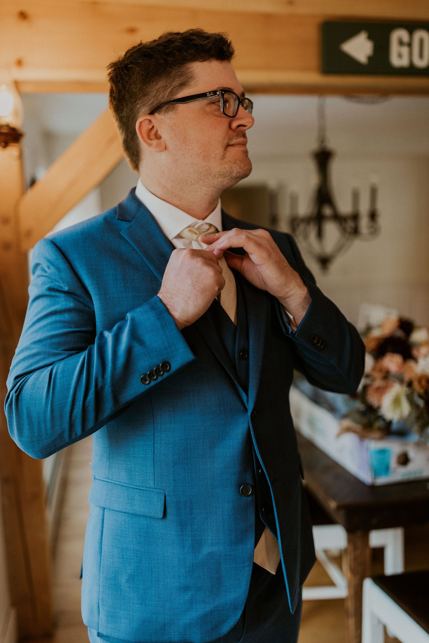 Daniel adjusting his tie as he prepares for the wedding ceremony on Loon Mountain.