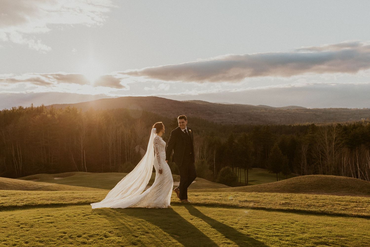 The bride and groom walking away together in the golden hour light at Owl's Nest Resort in Thornton, New Hampshire.