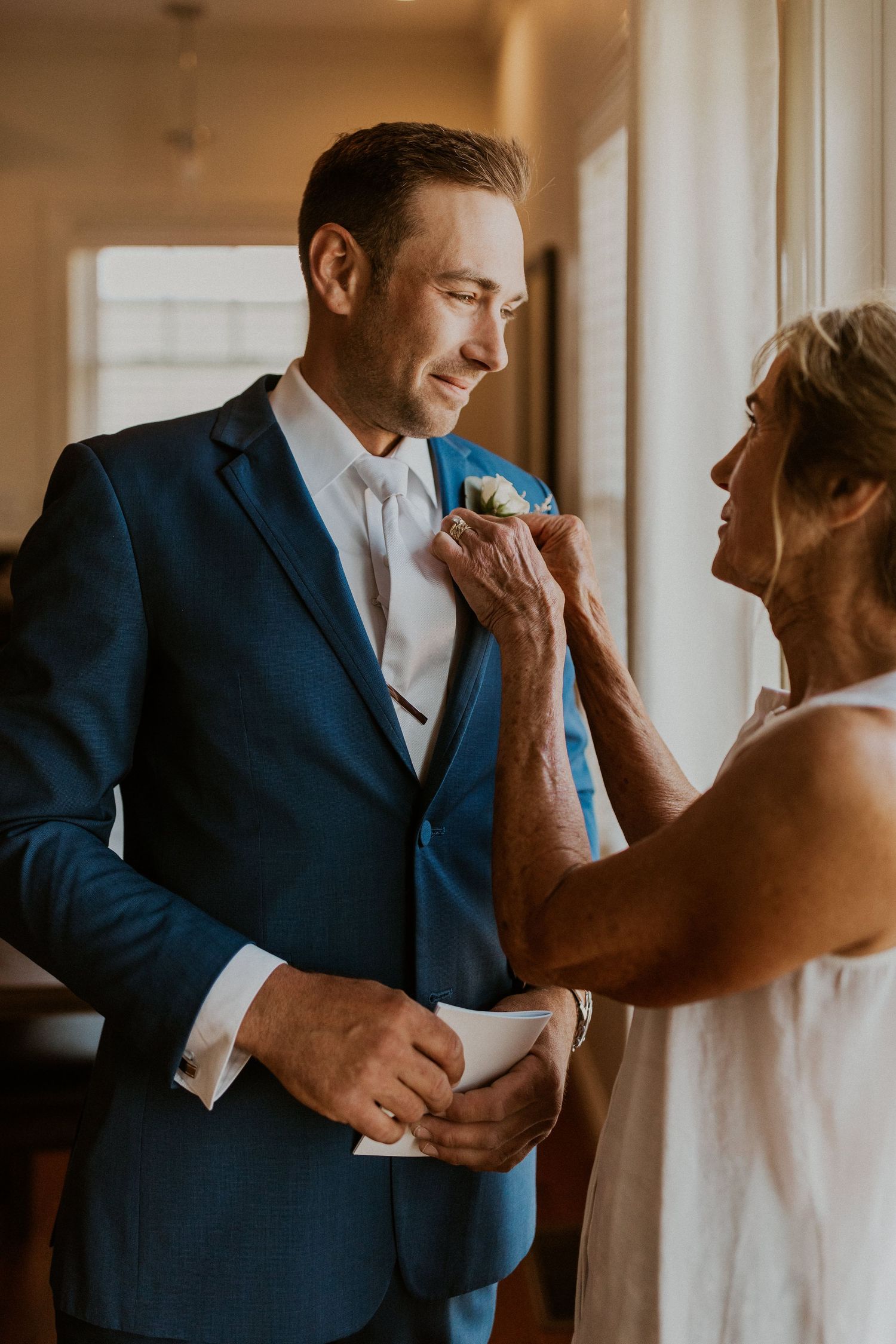 Andrew having his bouttinierre pinned by his mother before his wedding ceremony at Owl's Nest Resort Lake House.