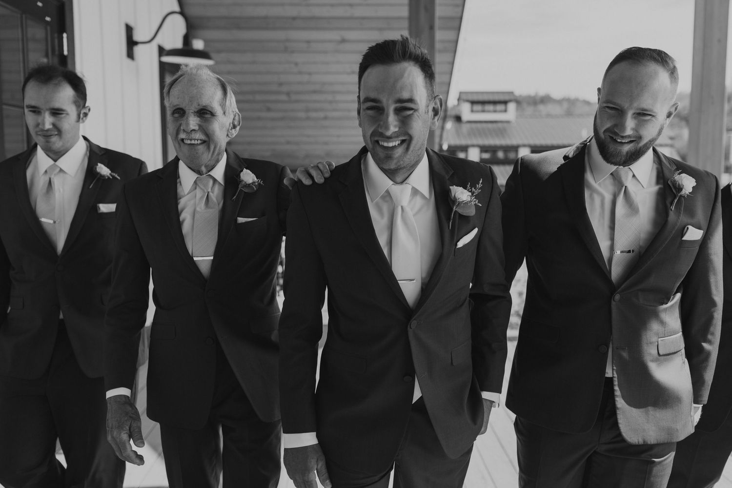Andrew and his groomsmen posing for groomsmen photos on the balcony at the Lake House at Owls Nest Resort in Thornton NH