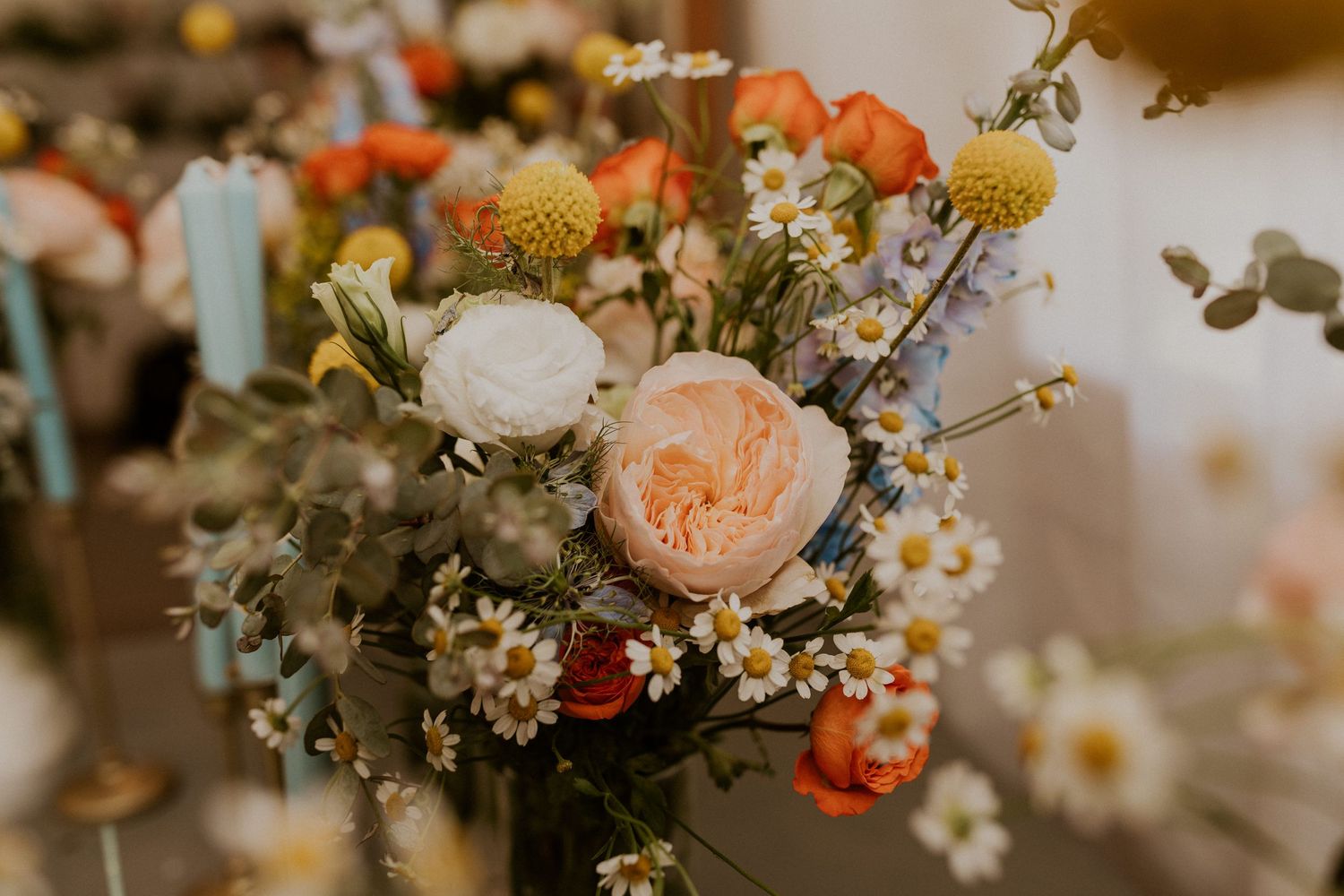 Romantic floral arrangement with peach roses and white daisies in soft vintage lighting.