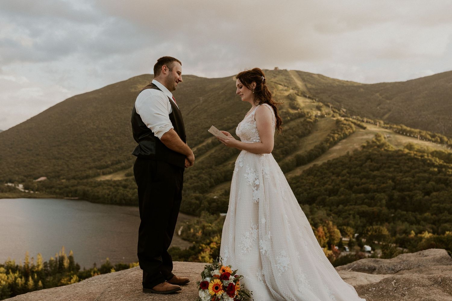 The bride reading her vows privately to the groom on the top of Artist Bluff in Franconia New Hampshire.