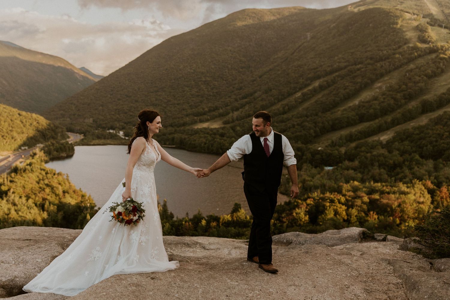 The groom leading the bride across the New Hampshire mountain top.
