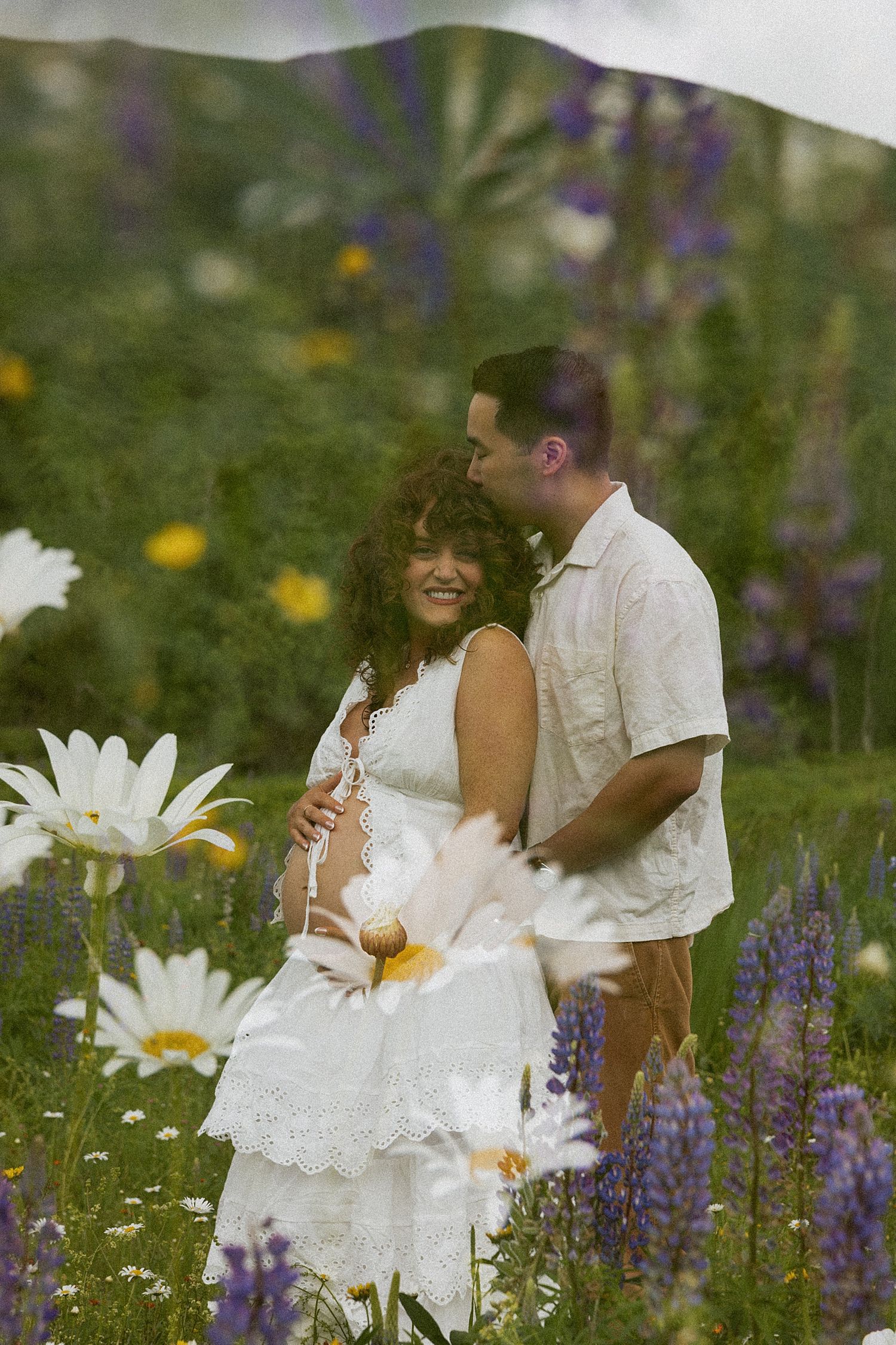 Pregnant couple taking maternity photos in a wildflower field in New Hampshire