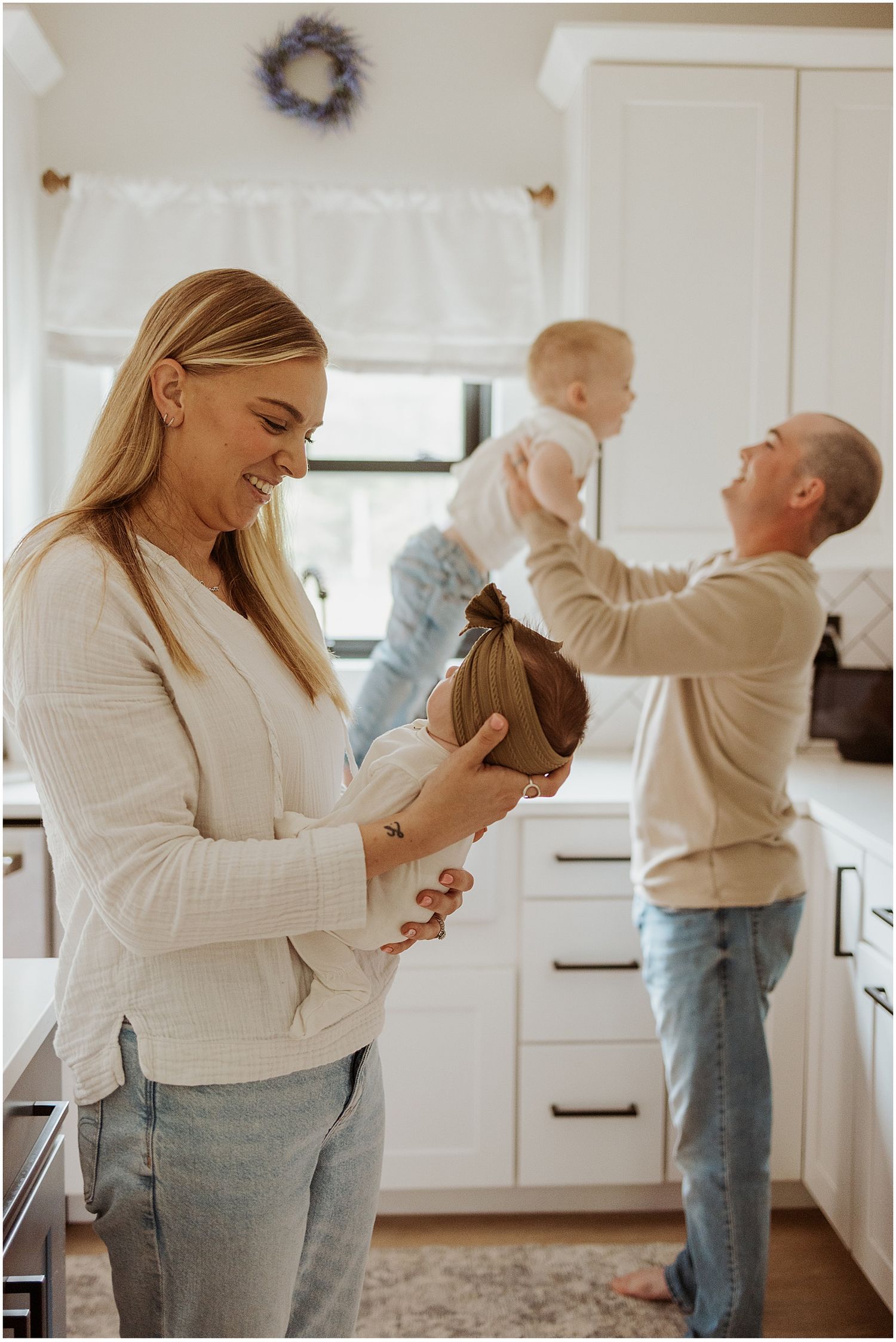 New Hampshire family taking newborn family photos at home in their kitchen.