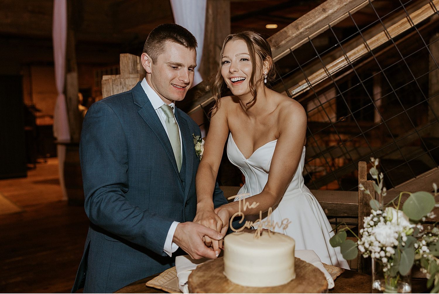 Bride and groom cutting their cake at their NH wedding at the Barn on the Pemi