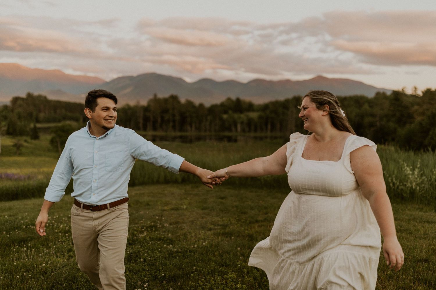 Terise and Jose playfully walking together in a lupine field in Sugar Hill NH during their engagement photos.