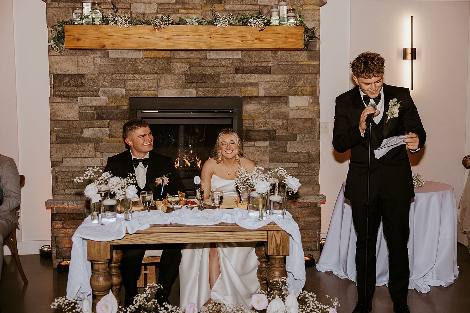 Groomsmen giving a speech at a New Hampshire wedding ceremony while the bride and groom listen and laugh