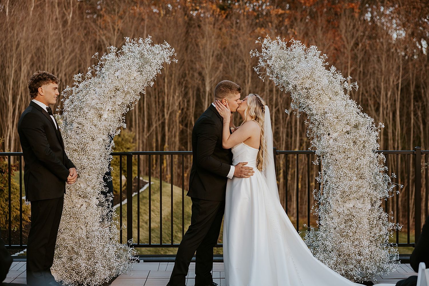 Bride and groom having their first kiss at their wedding ceremony at Hyla Brook Estate