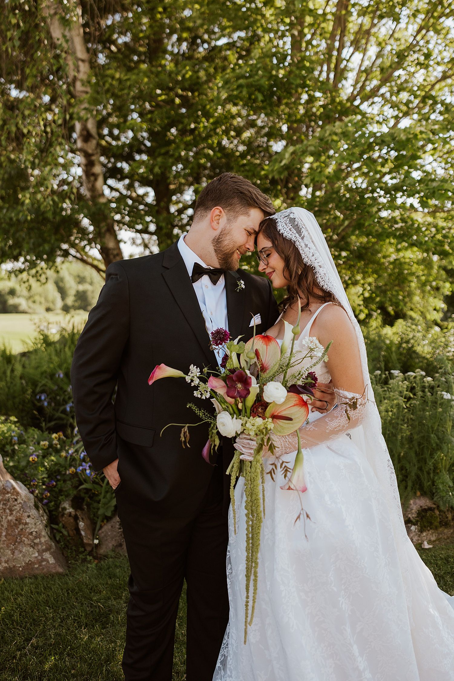Bride and groom taking portrait photos outside at their New Hampshire wedding