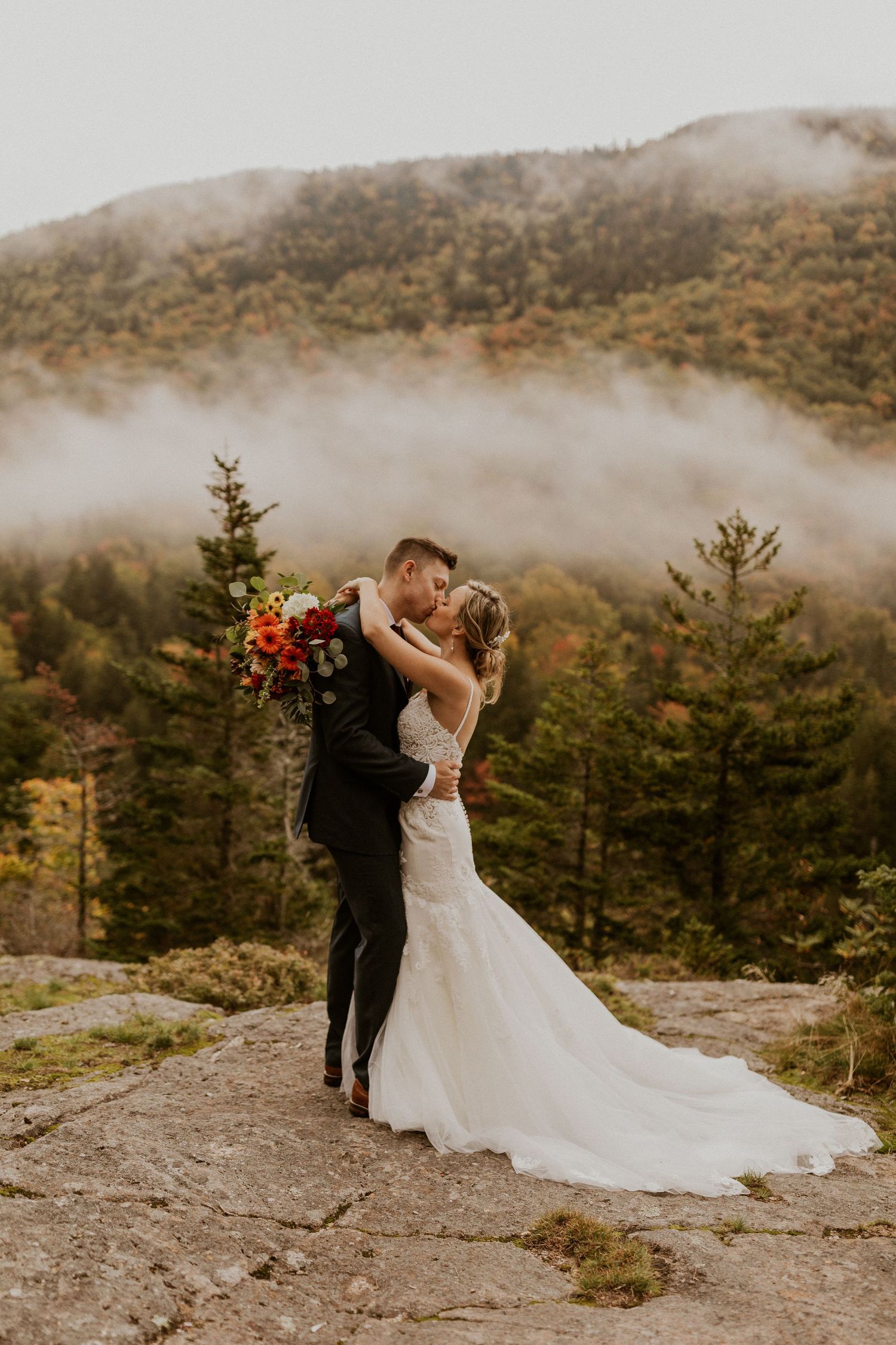 Newlyweds posing for mountaintop portraits in the White Mountain National Forest of New Hampshire.