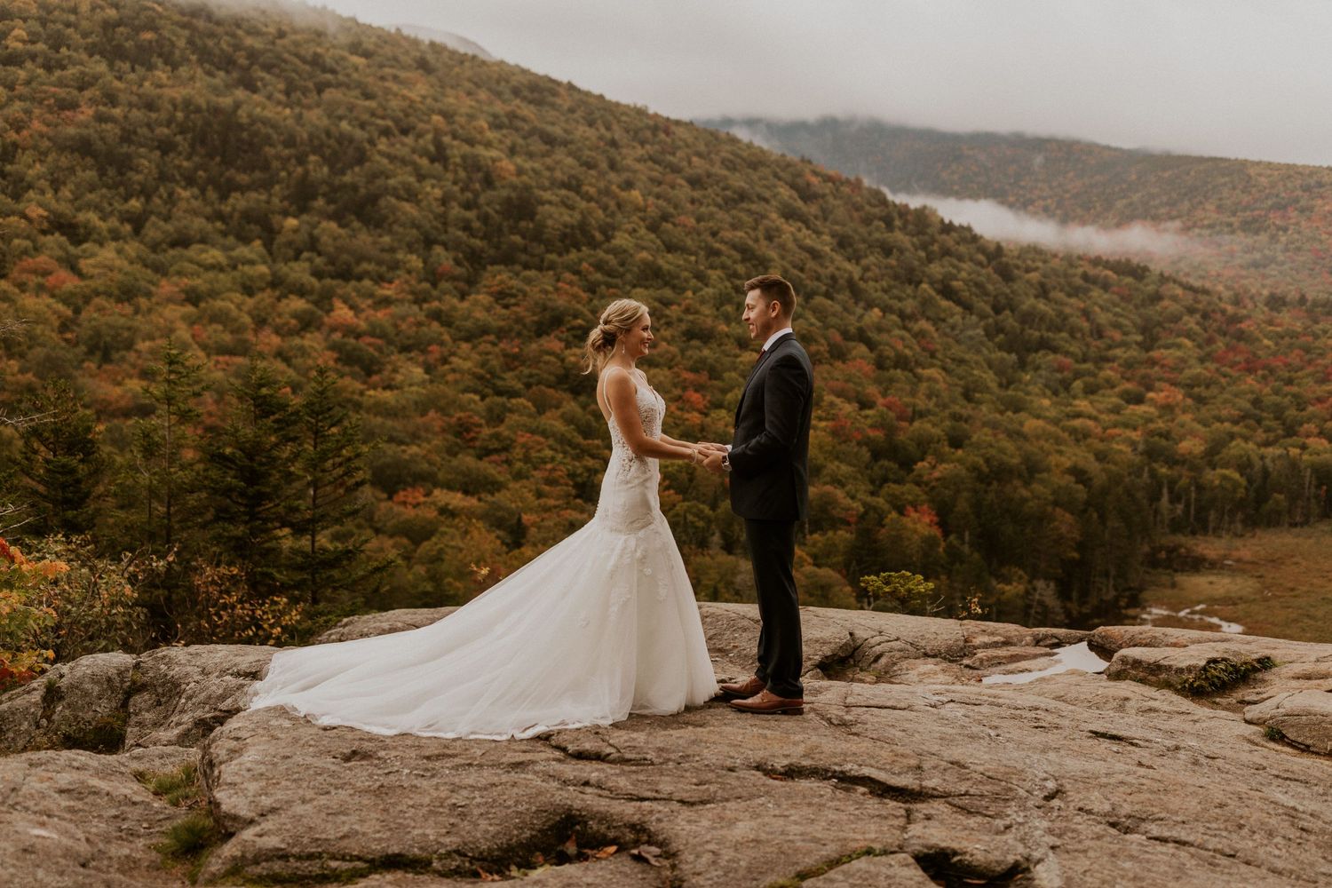 Newlyweds posing for mountaintop portraits in the White Mountain National Forest of New Hampshire.