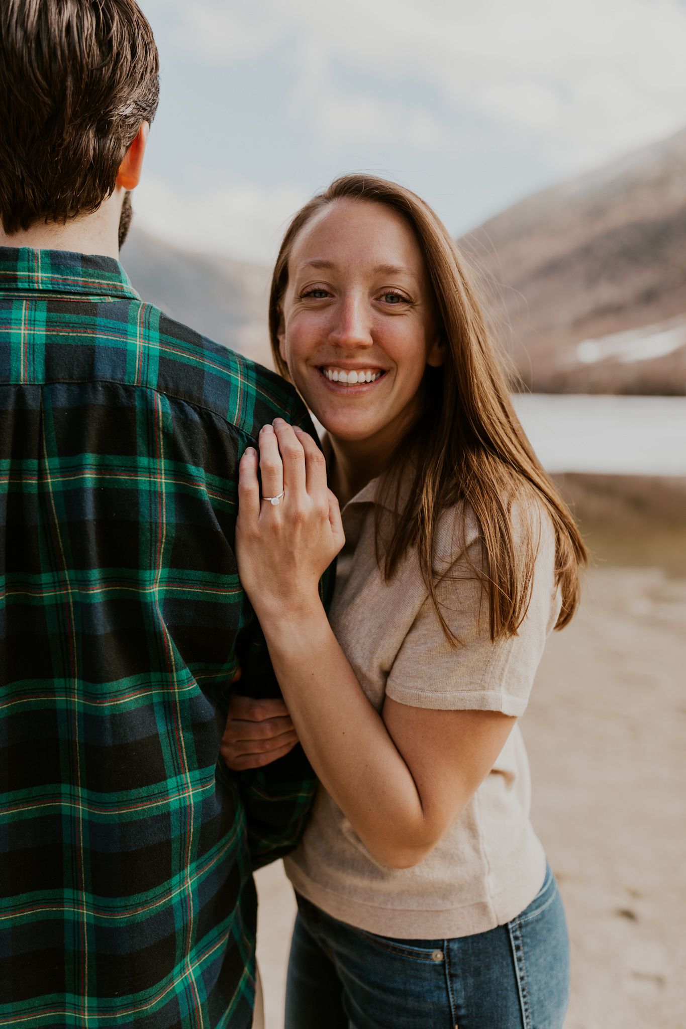 A happy couple standing in front of Echo Lake in Franconia Notch State Park
